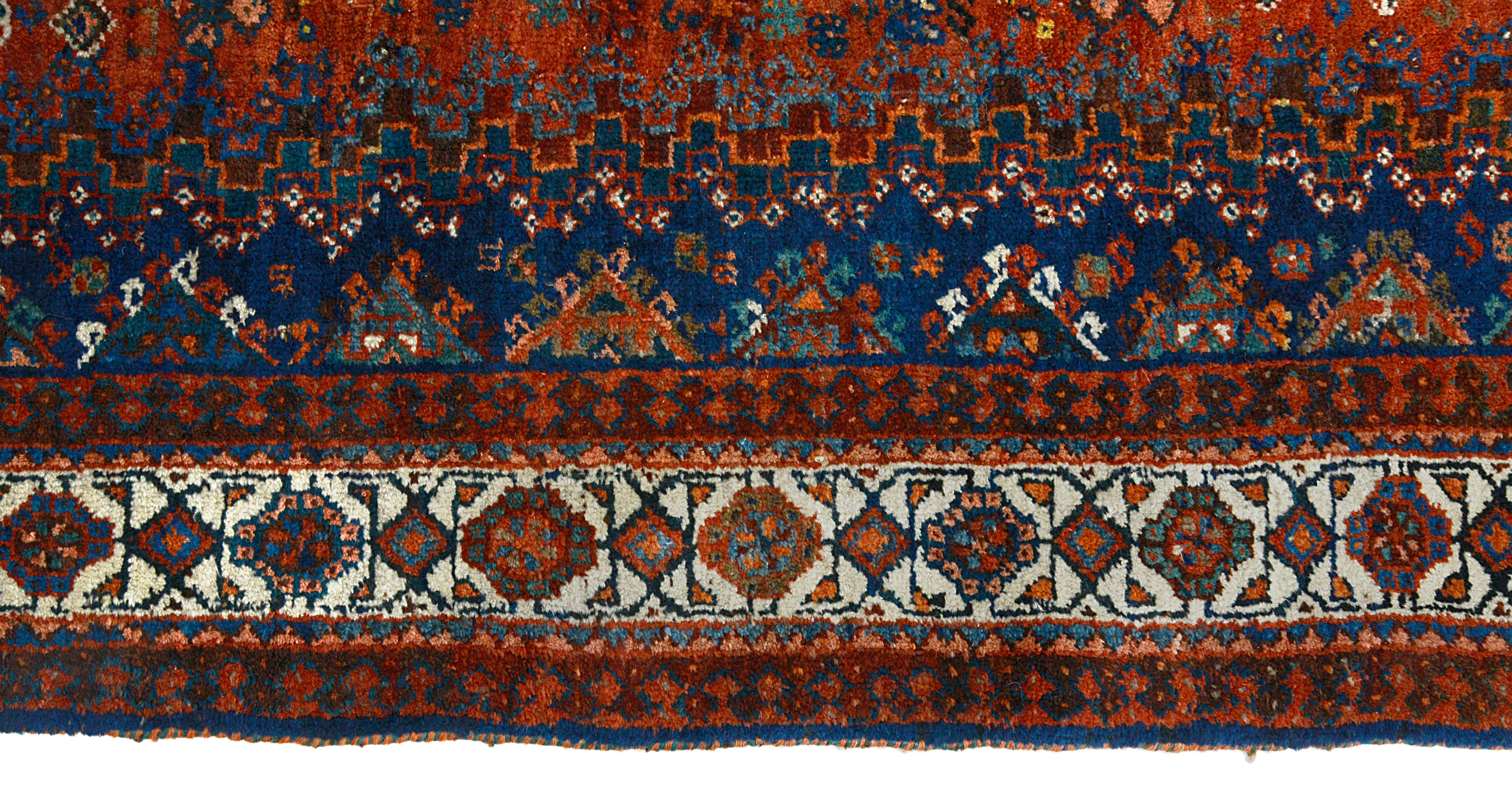 Border detail of an antique Persian Qashqai carpet with geometric tribal patterns
