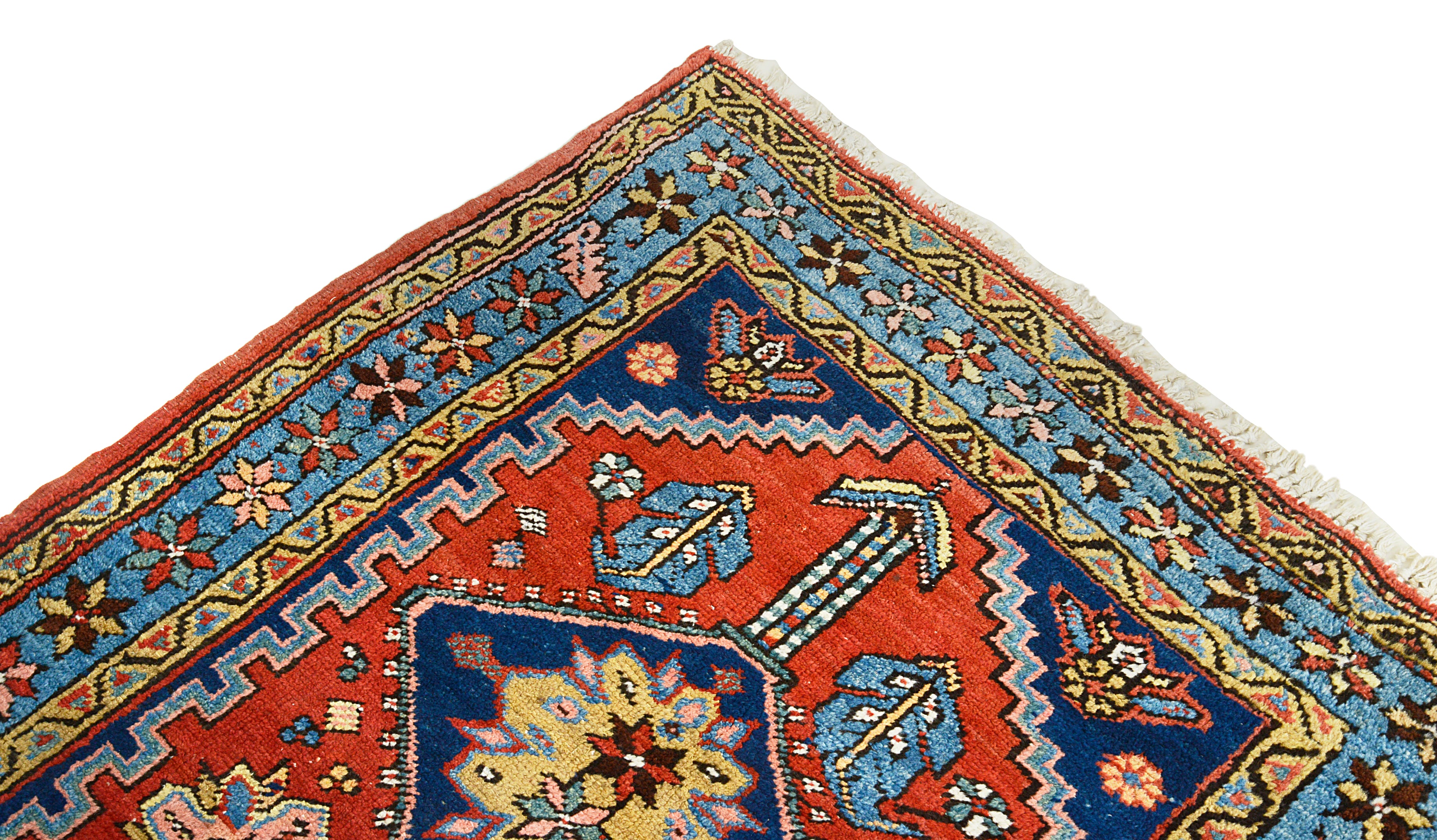 Close-up of a colorful patterned Persian Heriz rug corner with geometric designs.