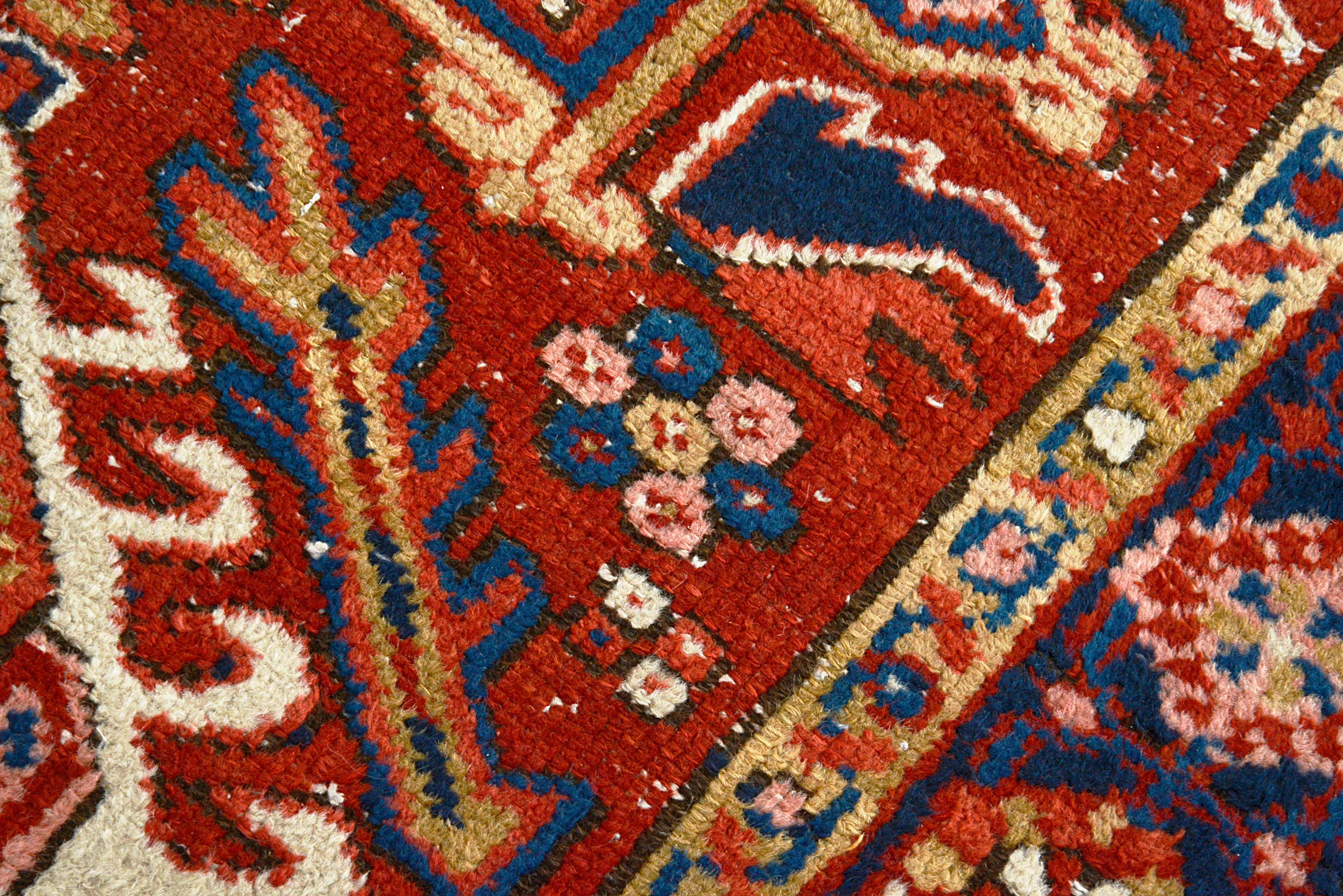 Close-up of a patterned handmade Persian Heriz rug with intricate designs and colors.