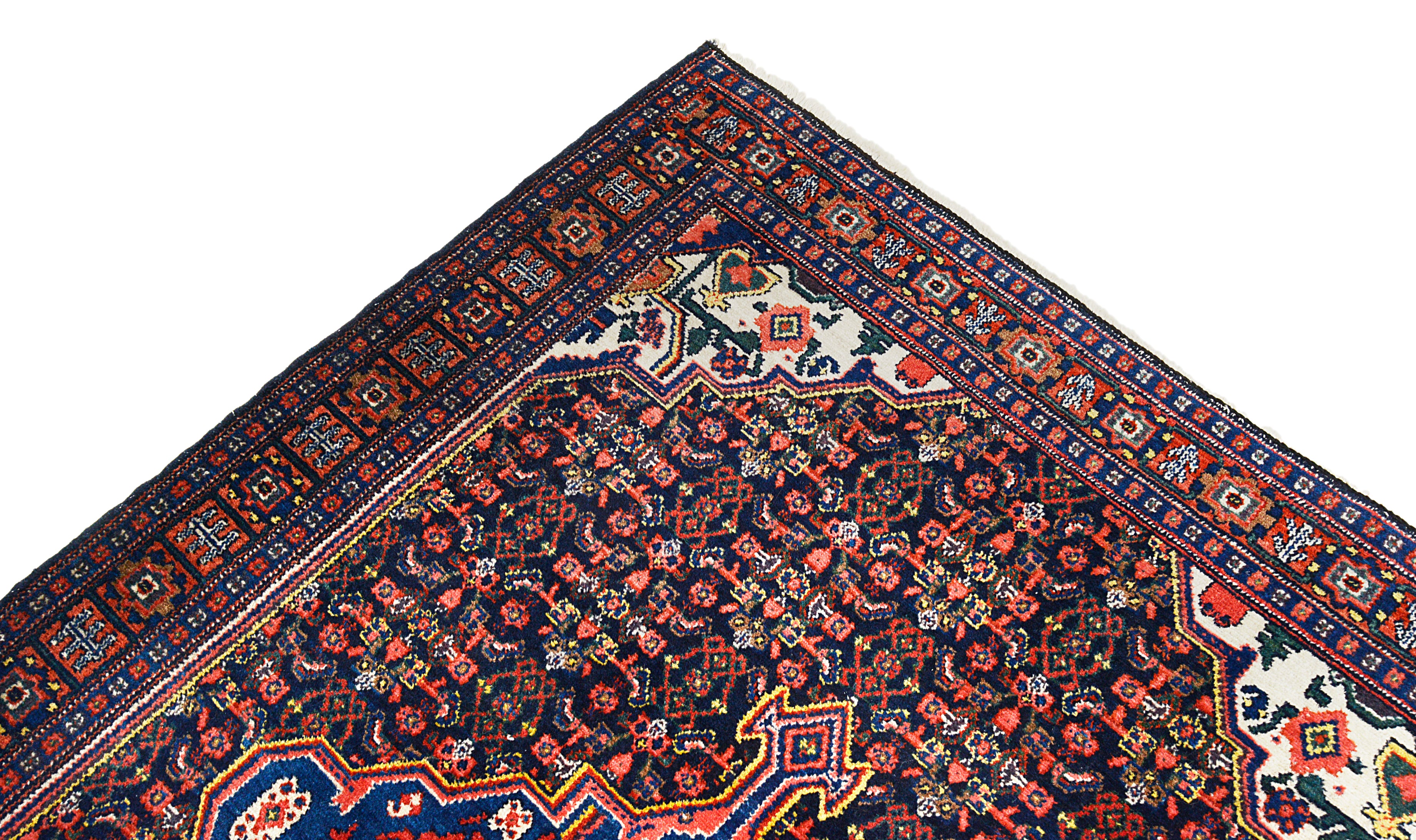 Close-up of a patterned Antique Persian rug corner with intricate designs.