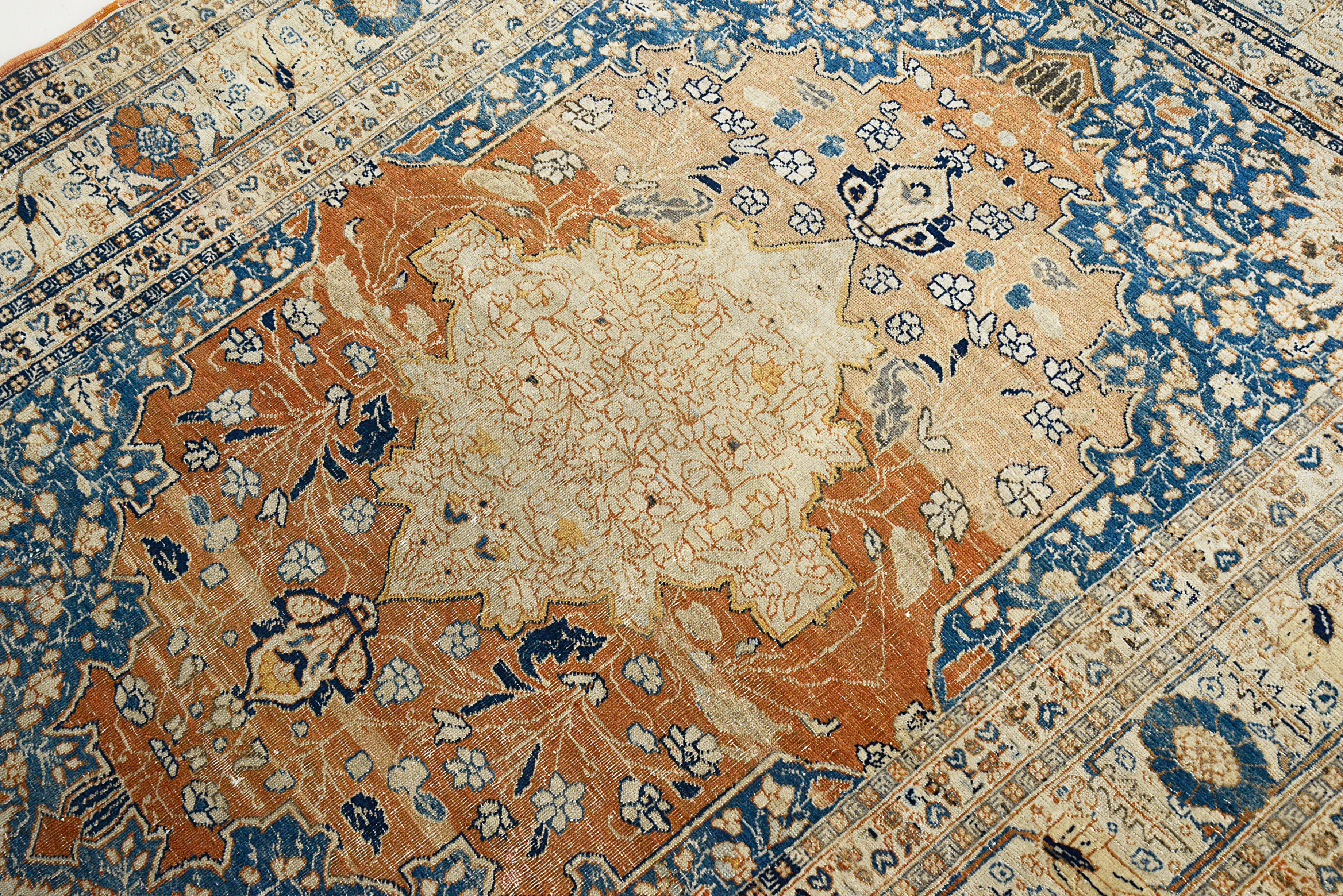 Close-up of an intricately designed Antique Tabriz rug with blue, brown, and beige colors.