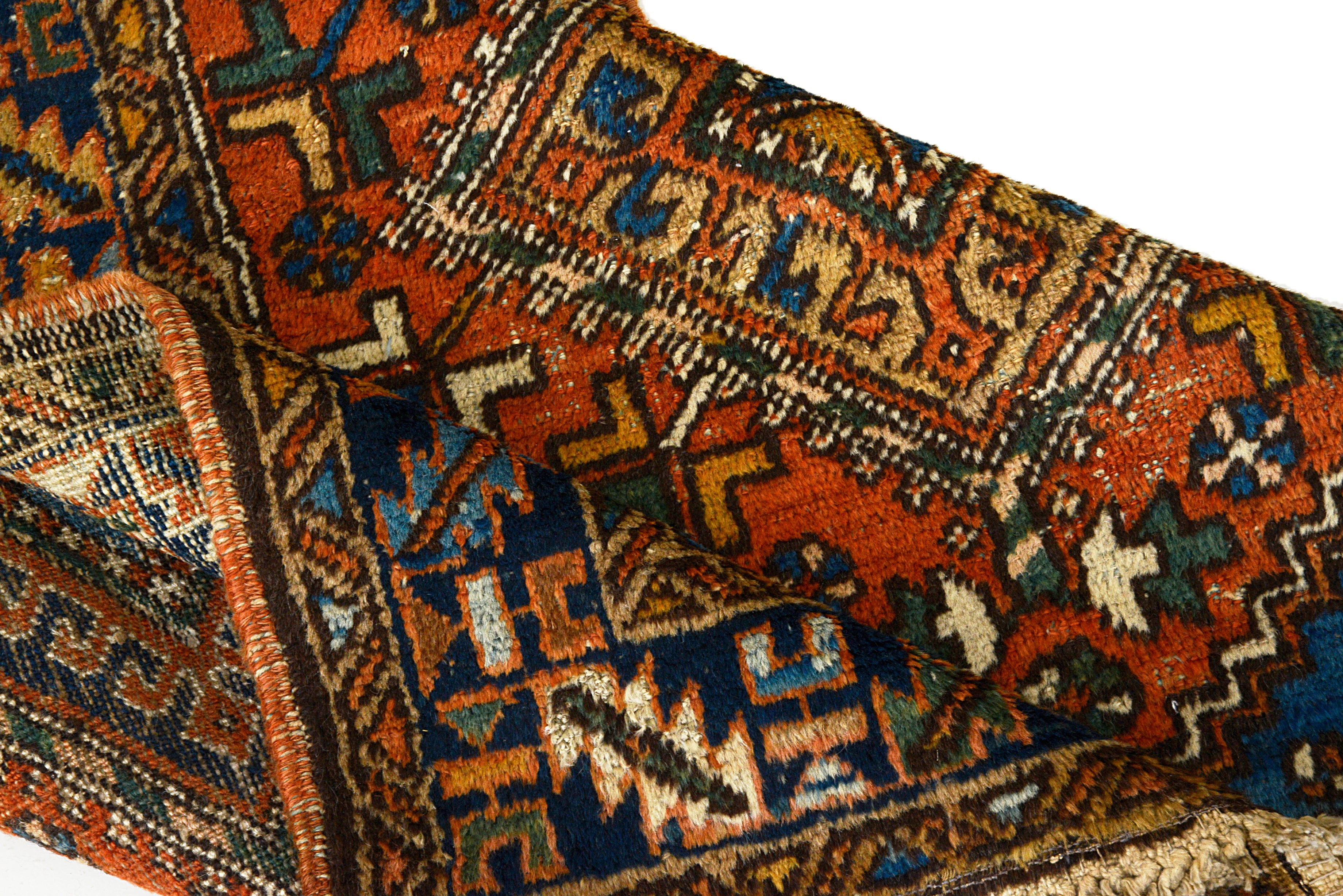 Close-up of hand-knotted wool pattern on an antique Persian Heriz rug