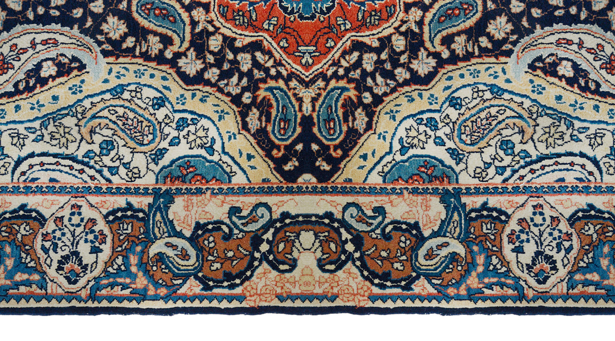 Detailed antique Sarouk rug border featuring floral motifs in ivory, blue and coral