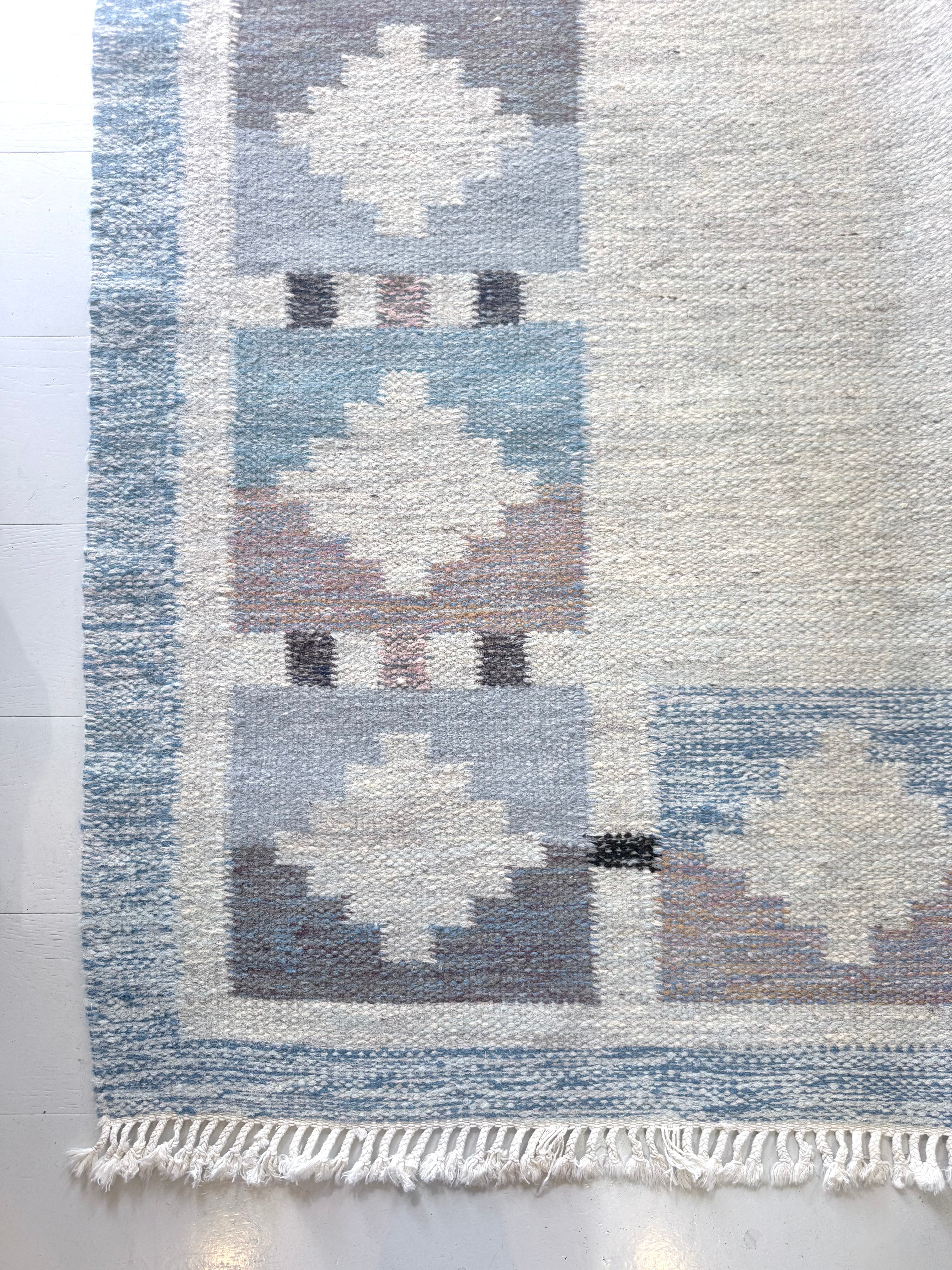 Close-up of vintage Swedish kilim rug with muted blue geometric motifs