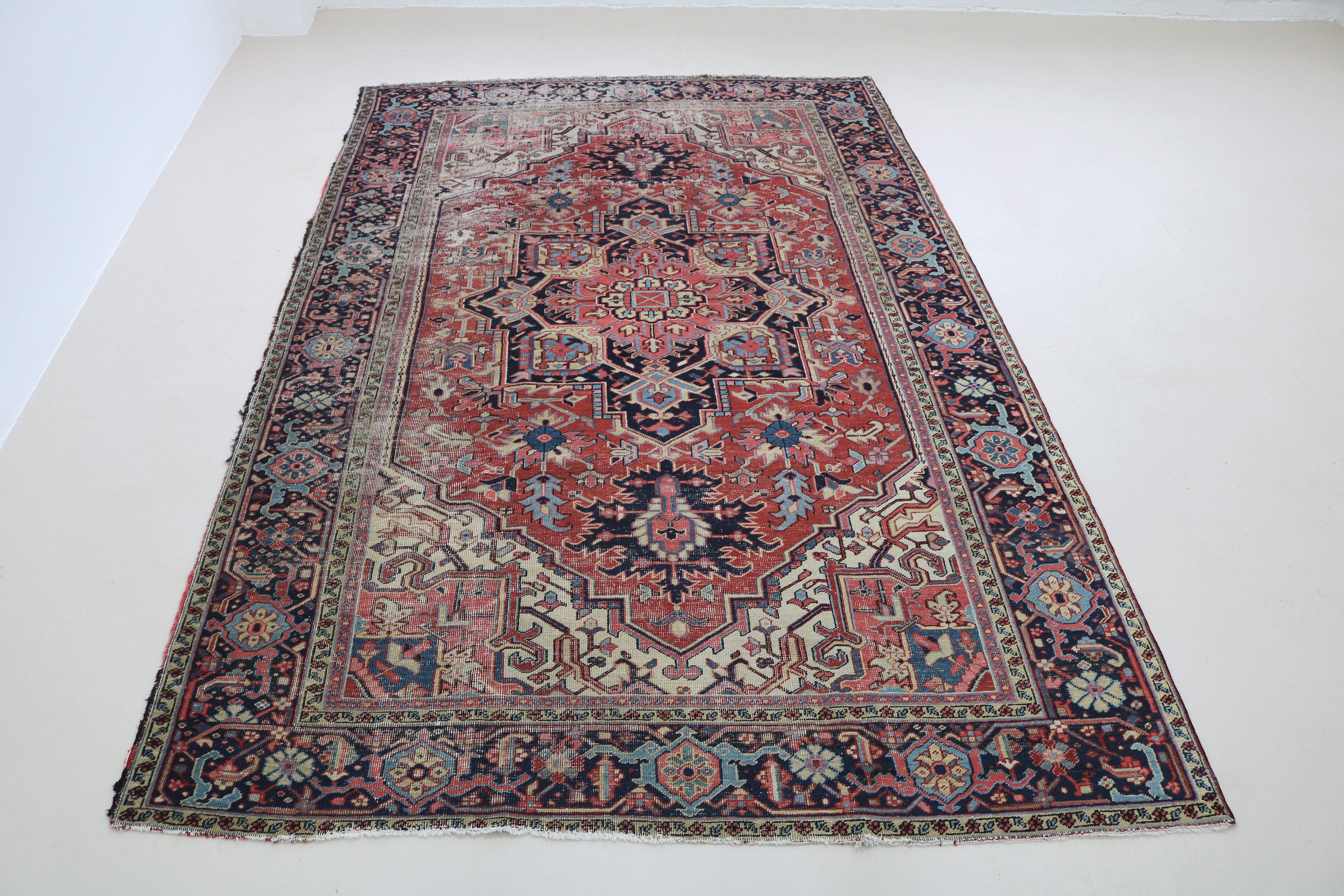 Full view of fine antique Persian Heriz carpet with strong geometric field and architectural borders
