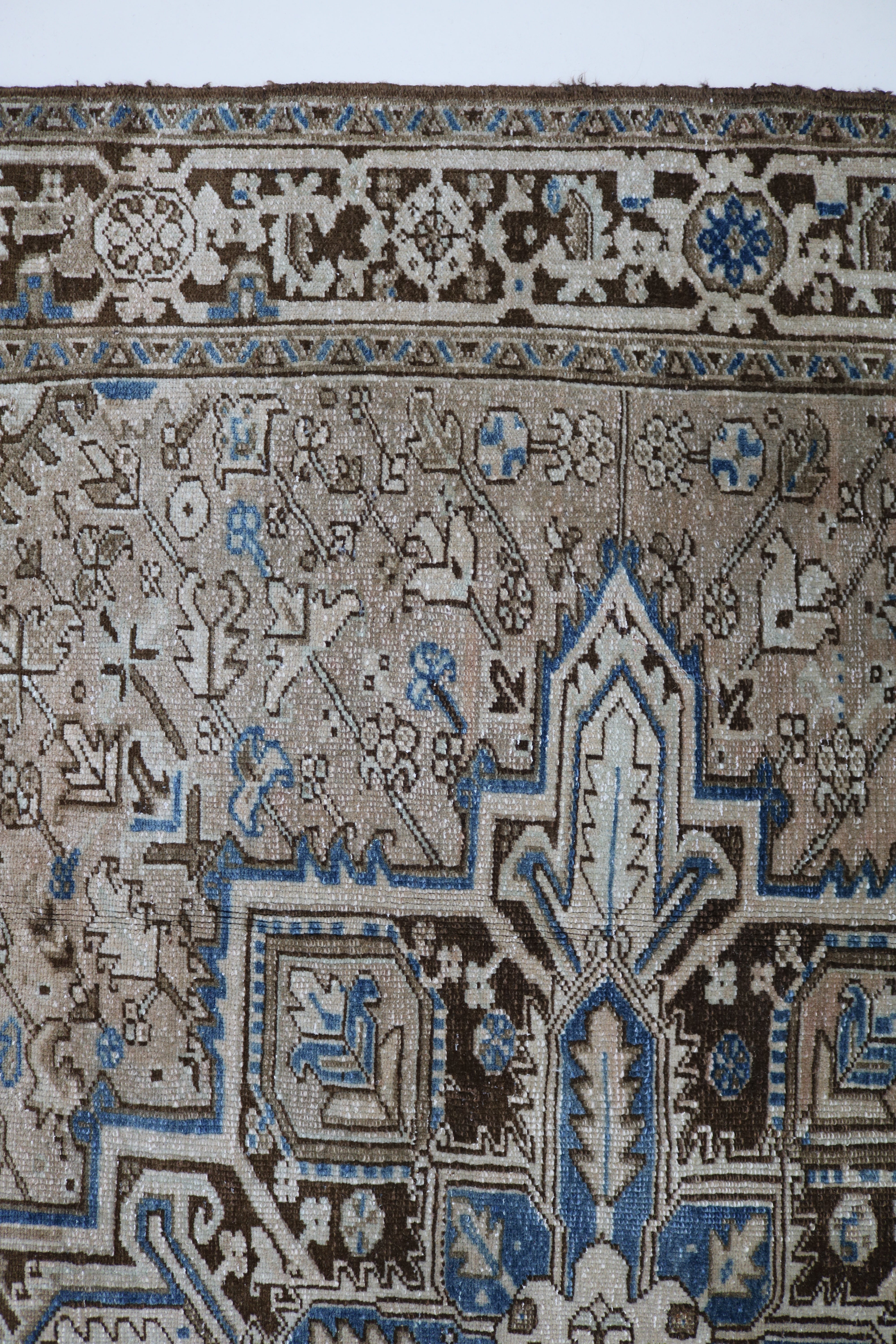 Close-up of hand-knotted wool texture on antique Persian Heriz carpet