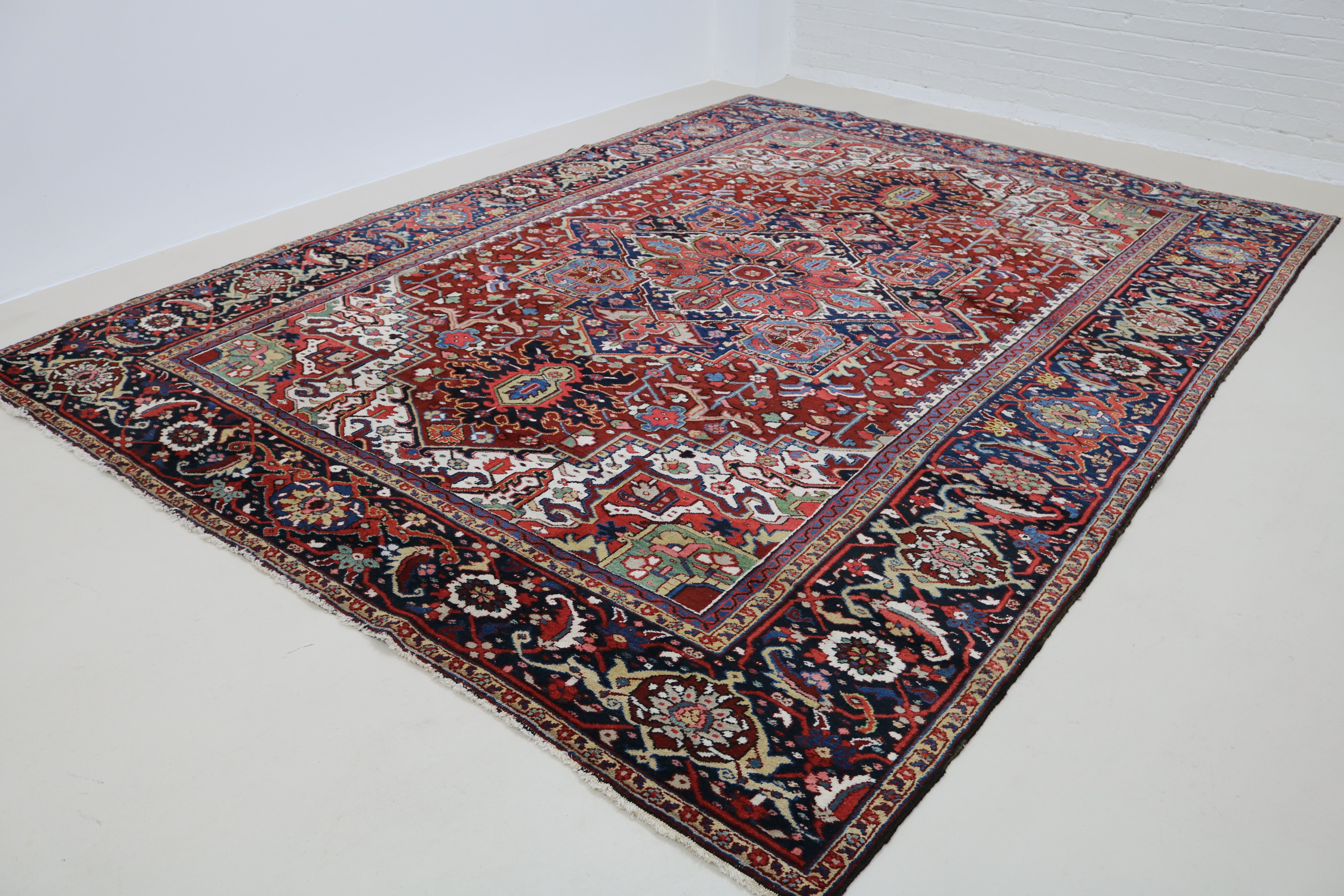 Angled view of fine antique Persian Heriz carpet highlighting overall pattern and composition
