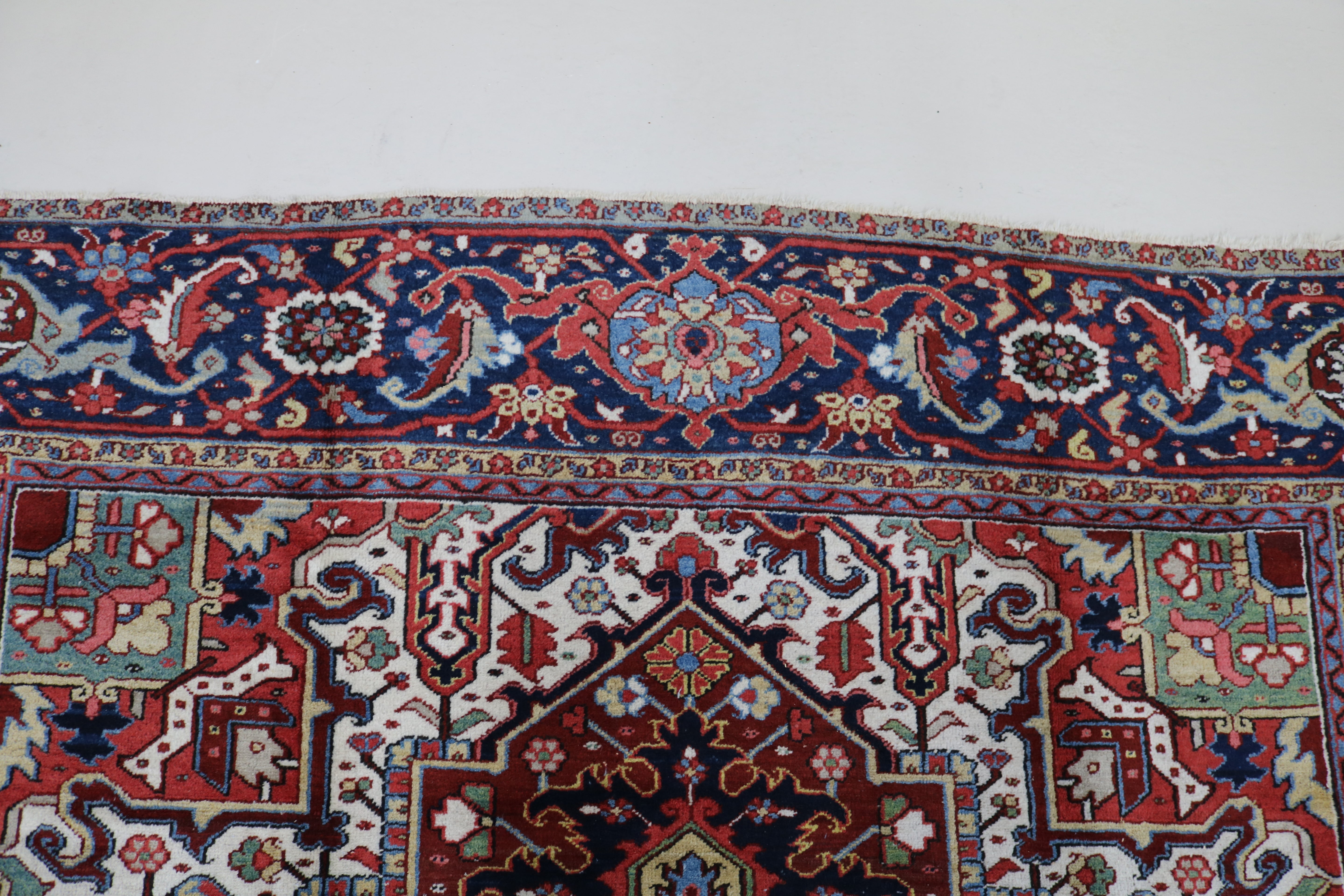Close-up of hand-knotted wool texture on fine antique Persian Heriz carpet
