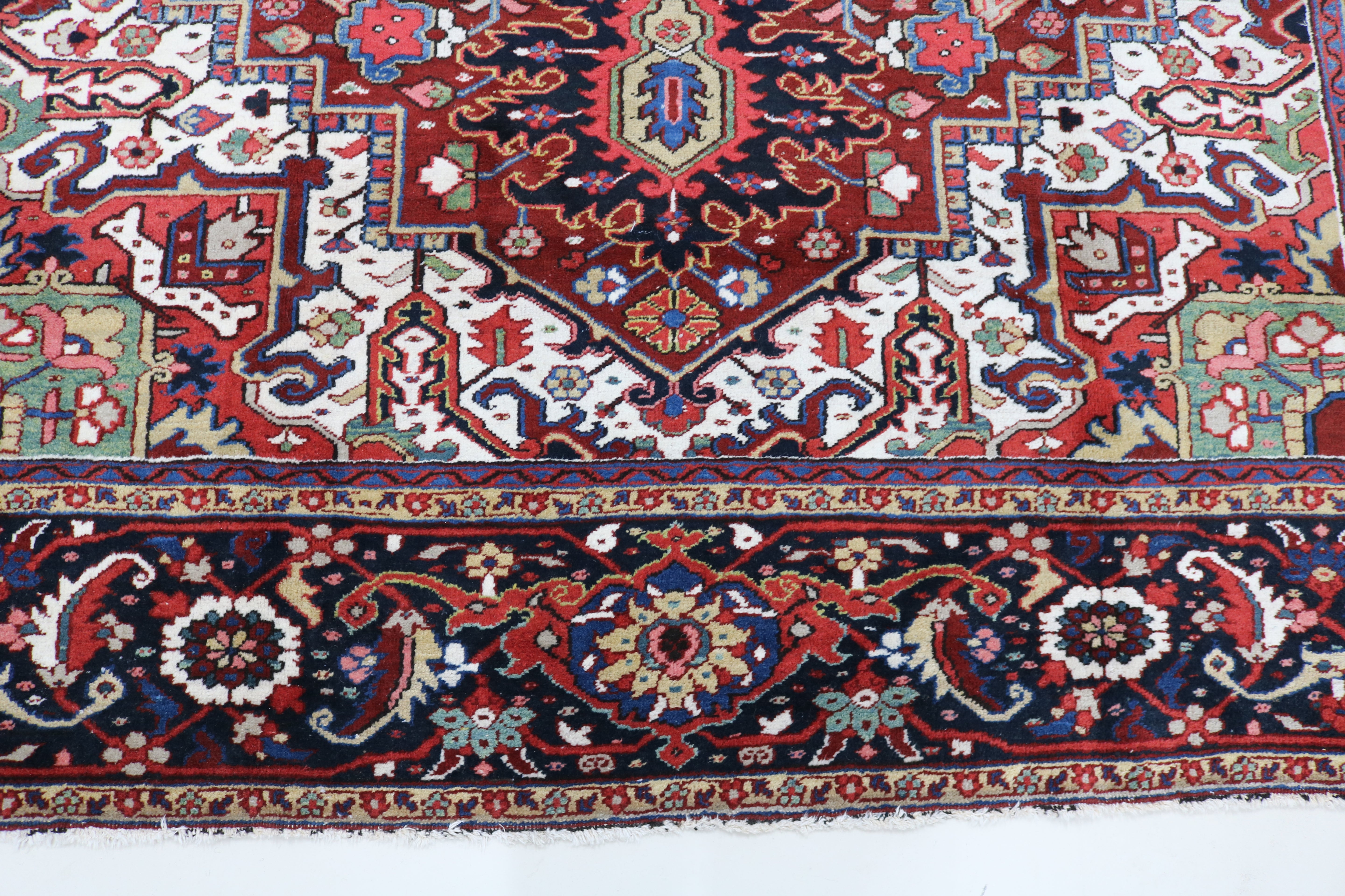 Close-up of hand-knotted wool texture on fine antique Persian Heriz carpet
