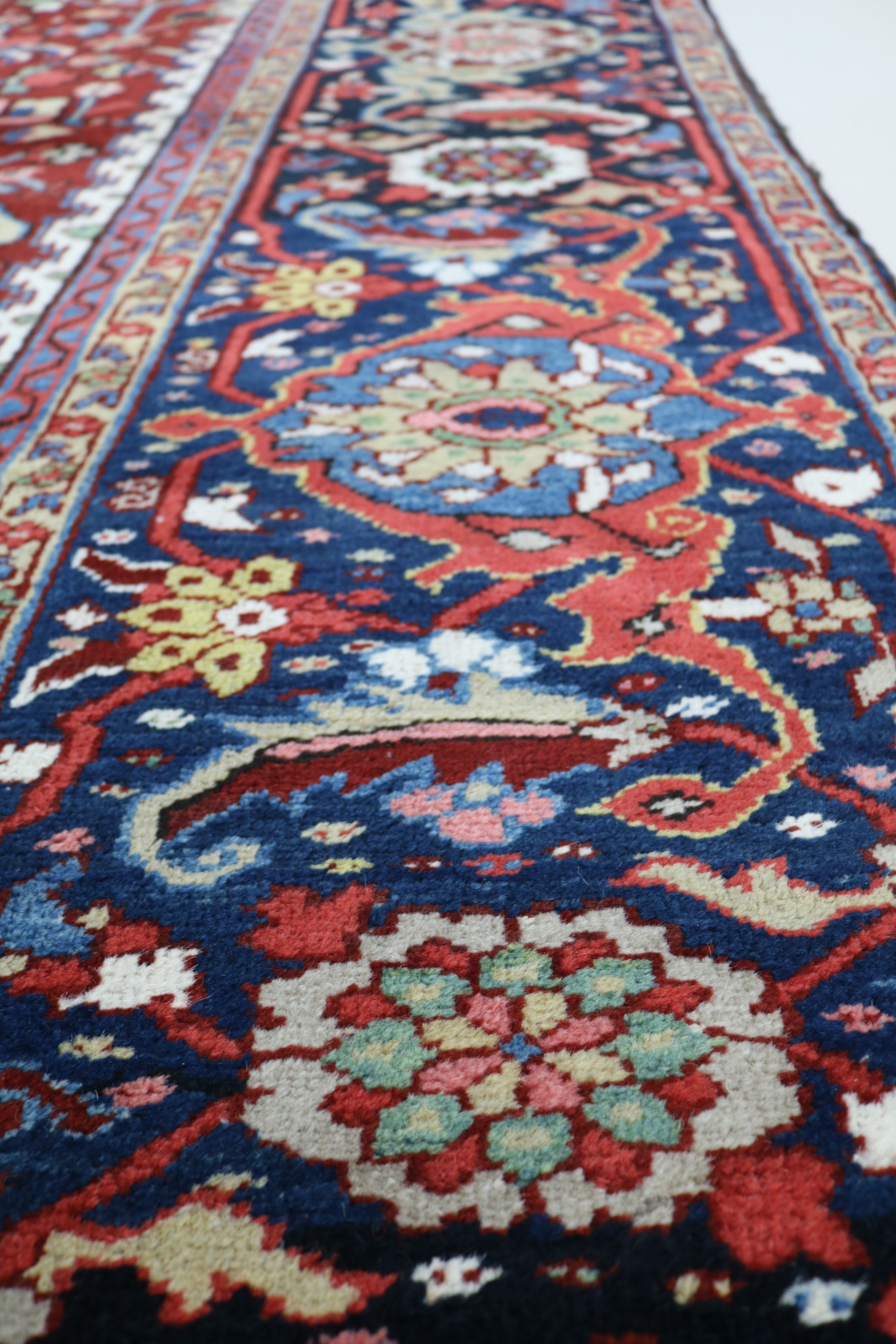 Close-up of hand-knotted wool texture on fine antique Persian Heriz carpet
