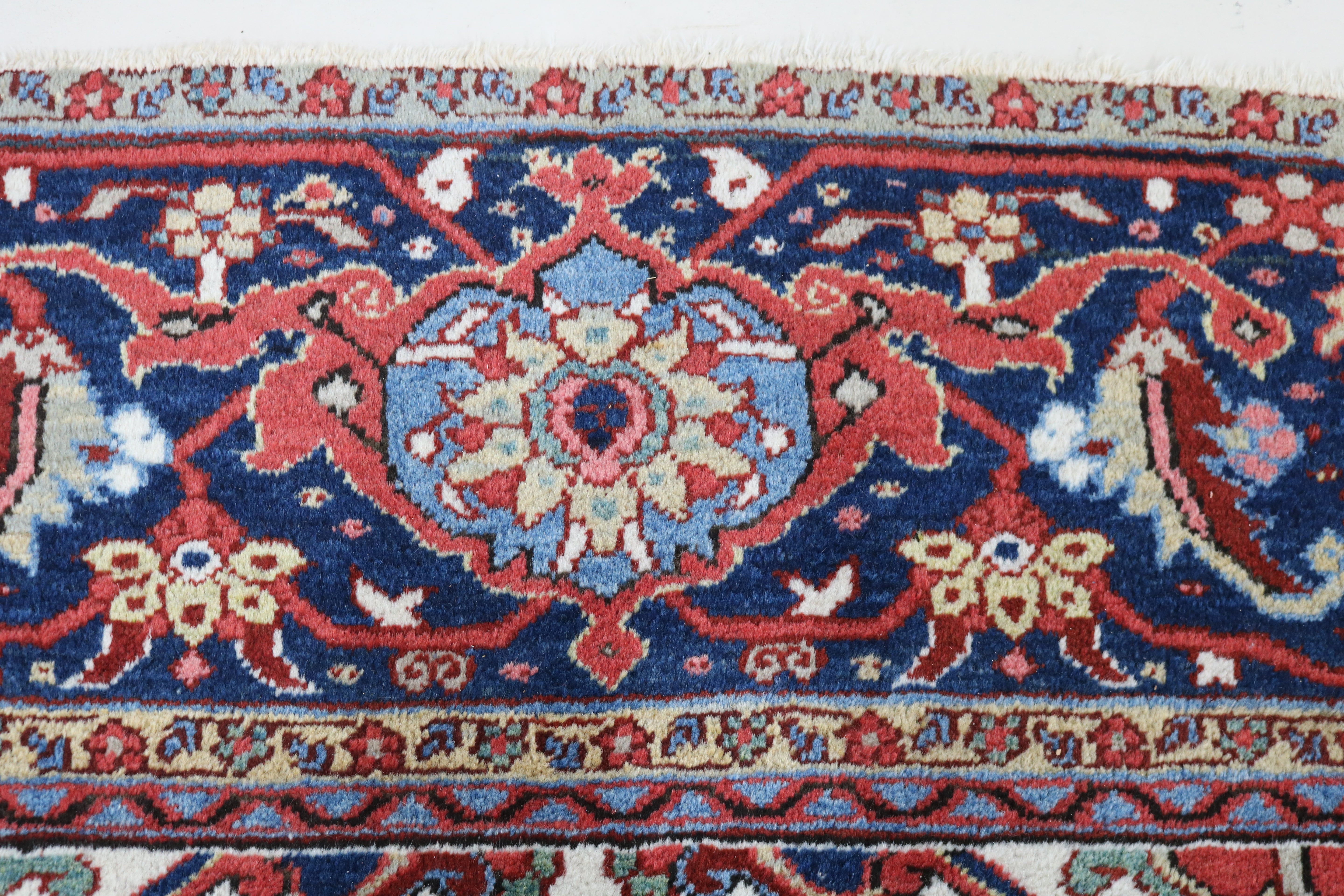 Close-up of hand-knotted wool texture on fine antique Persian Heriz carpet
