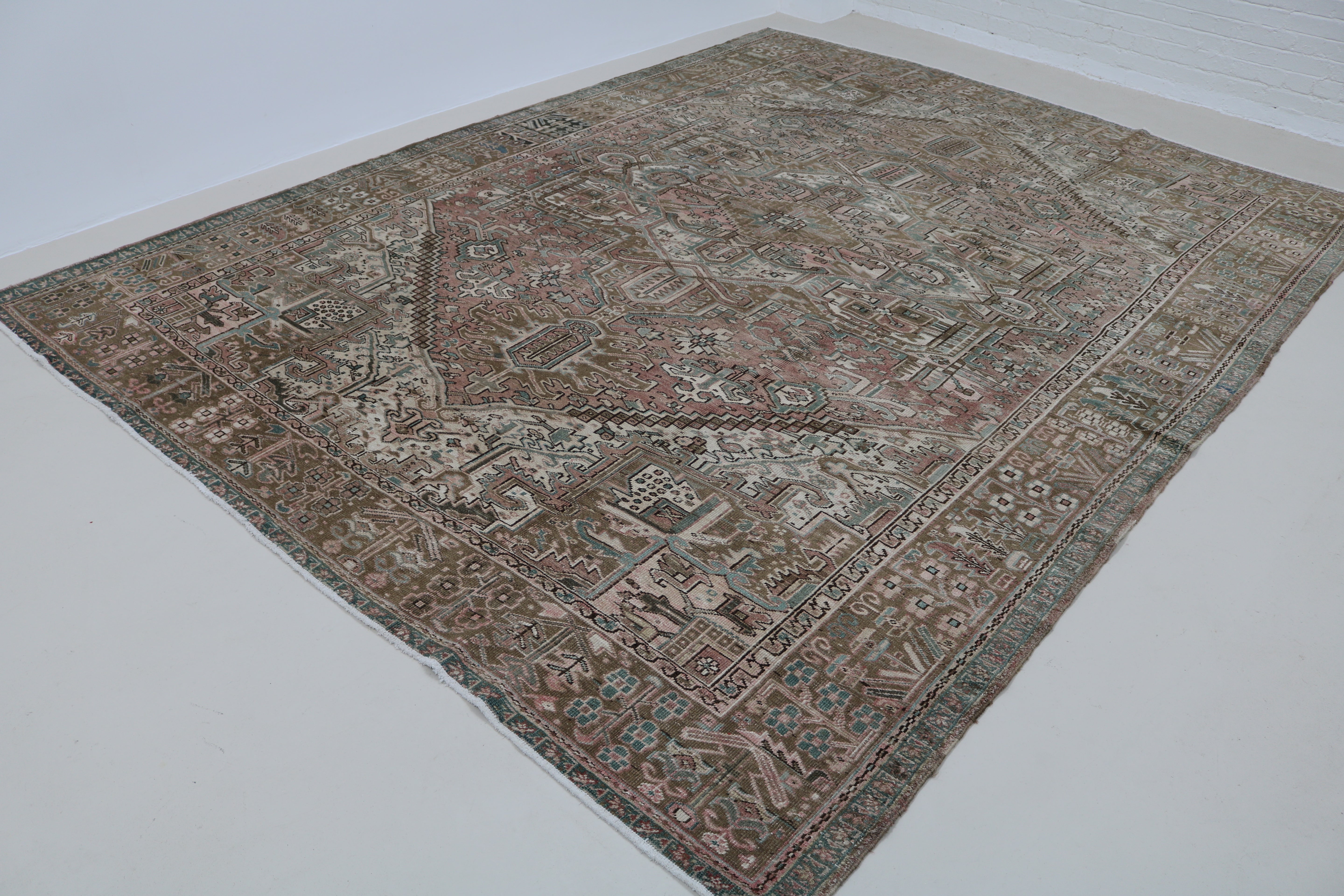 Angled view of antique Persian Heriz carpet highlighting overall pattern and proportions
