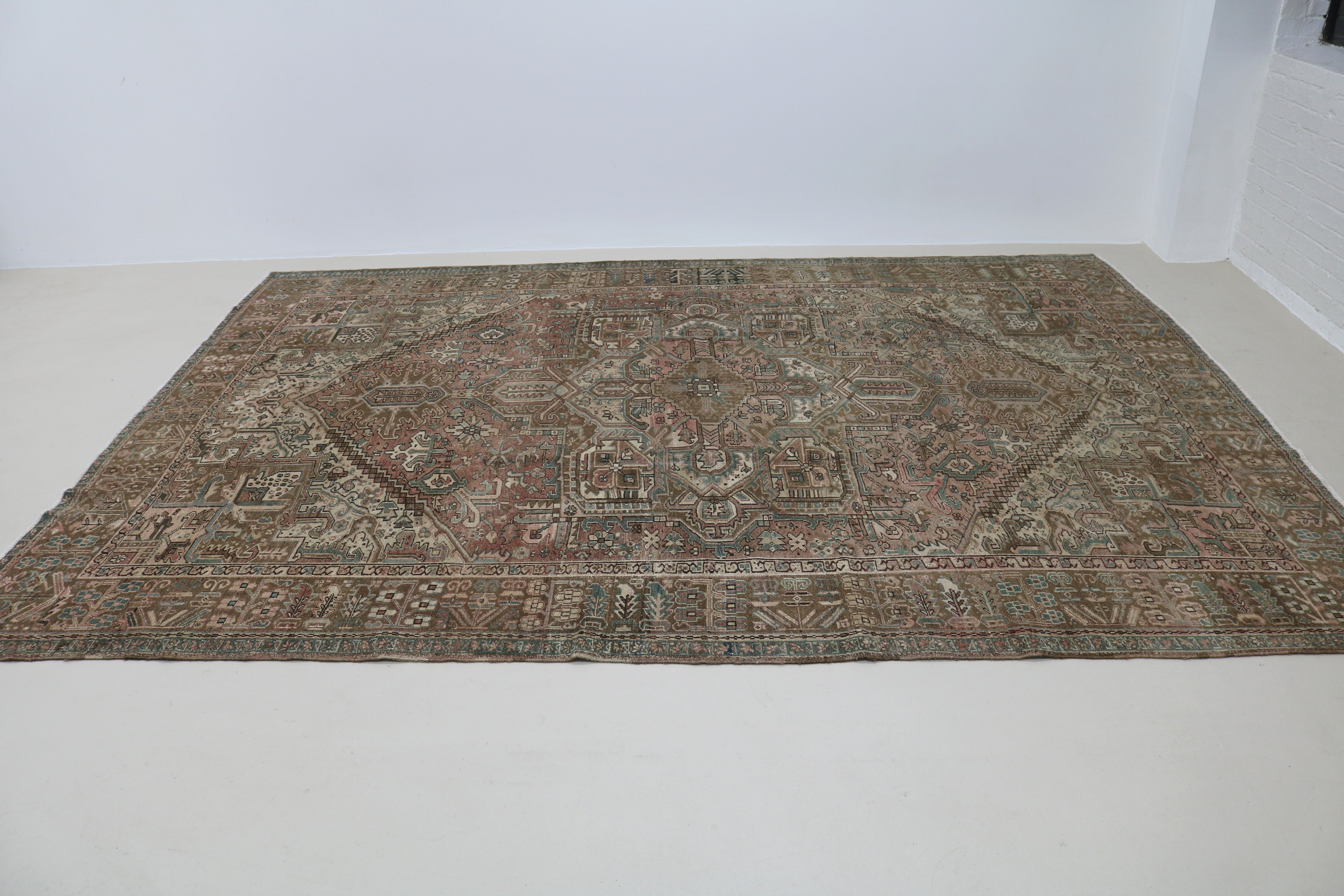 Perspective view of antique Persian Heriz carpet on floor

