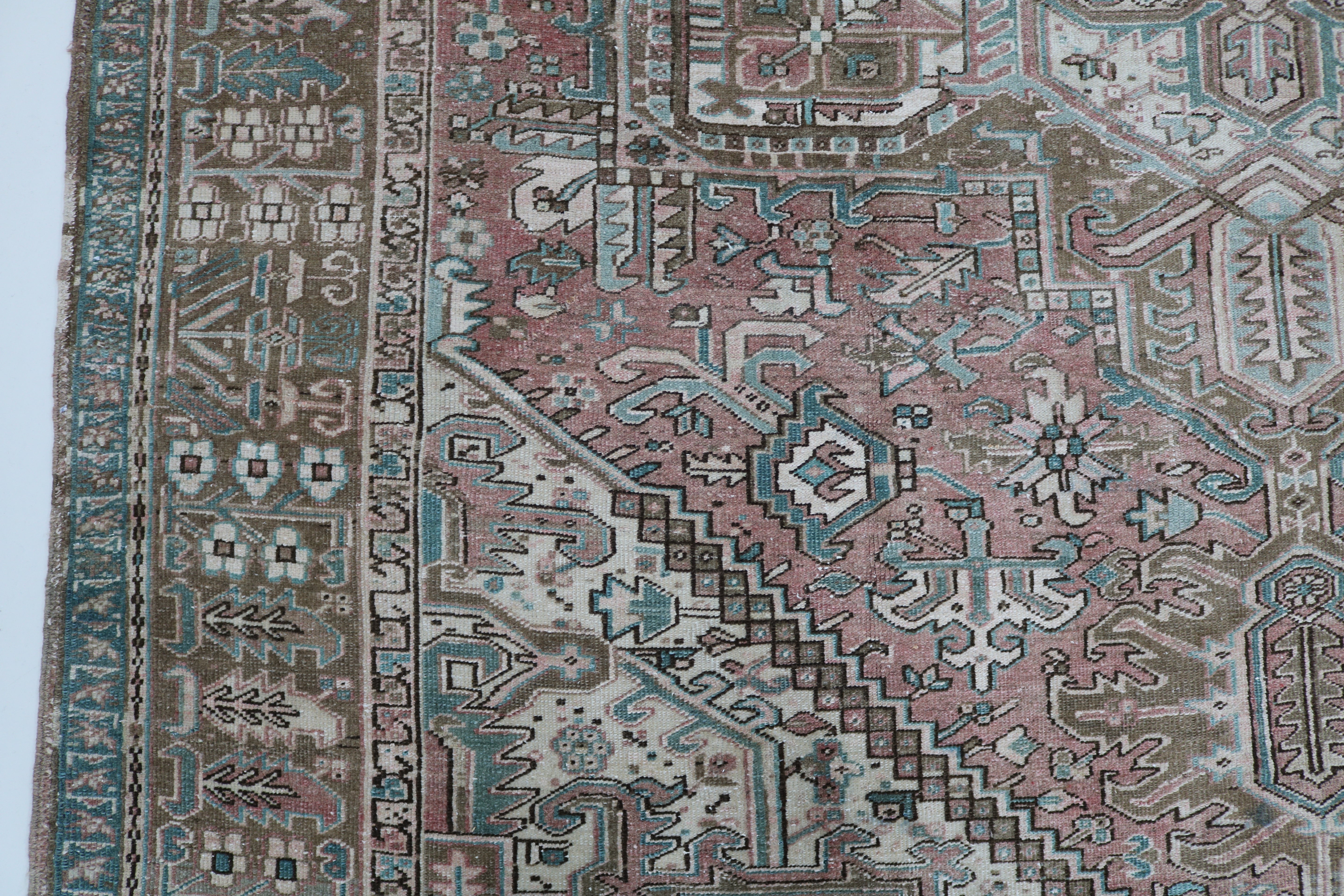 Close-up of hand-knotted wool texture on antique Persian Heriz carpet
