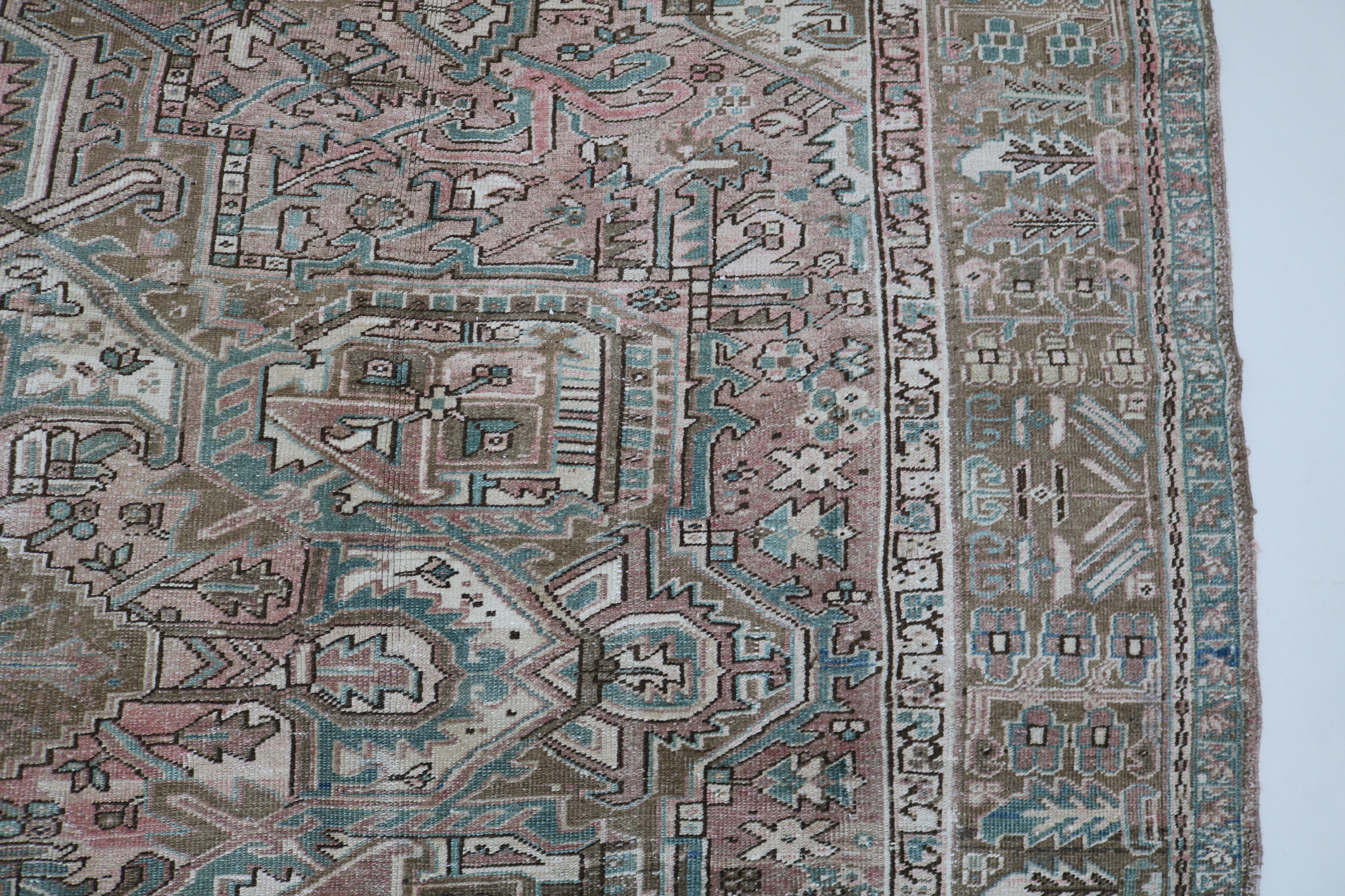 Close-up of hand-knotted wool texture on antique Persian Heriz carpet
