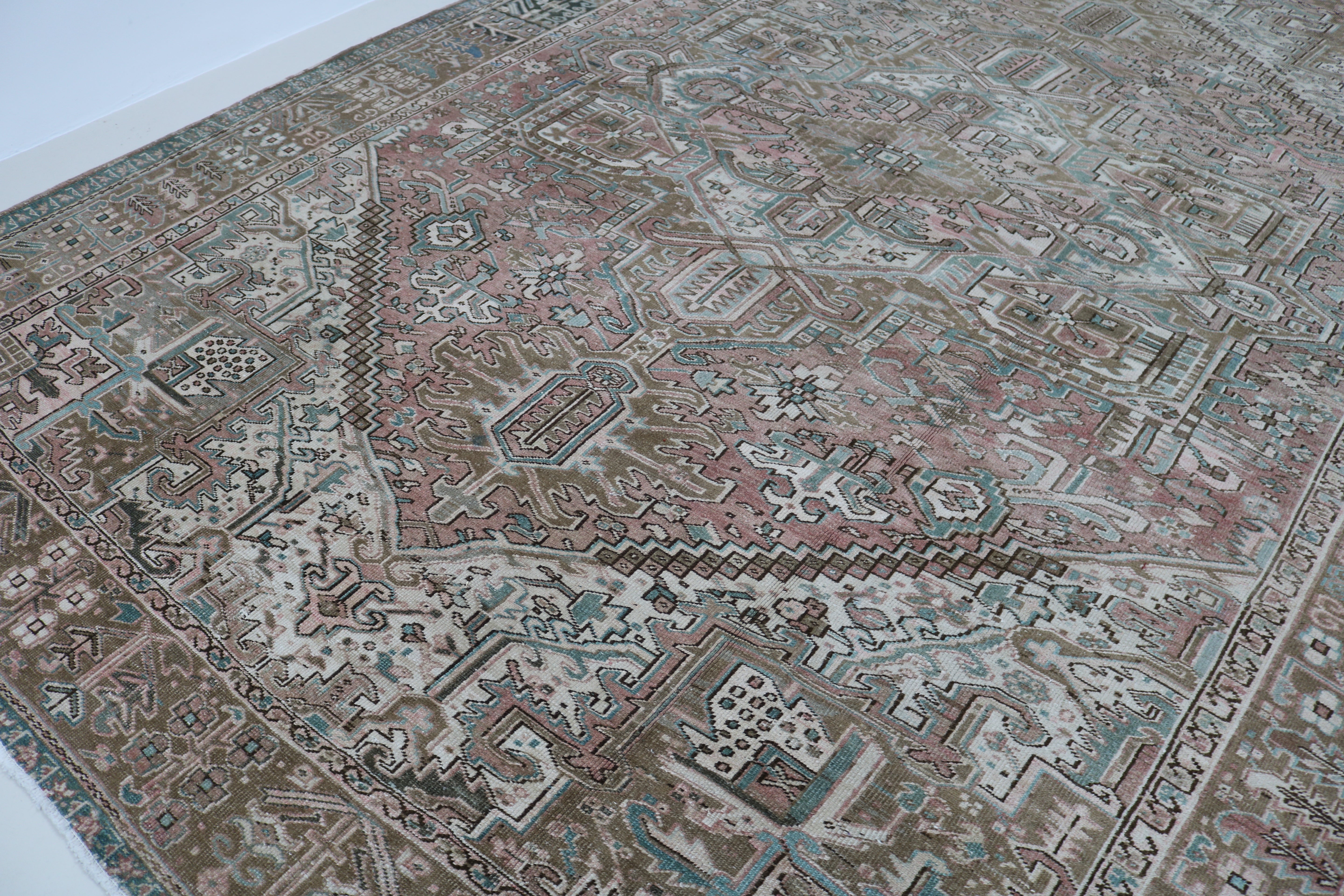 Close-up of hand-knotted wool texture on antique Persian Heriz carpet
