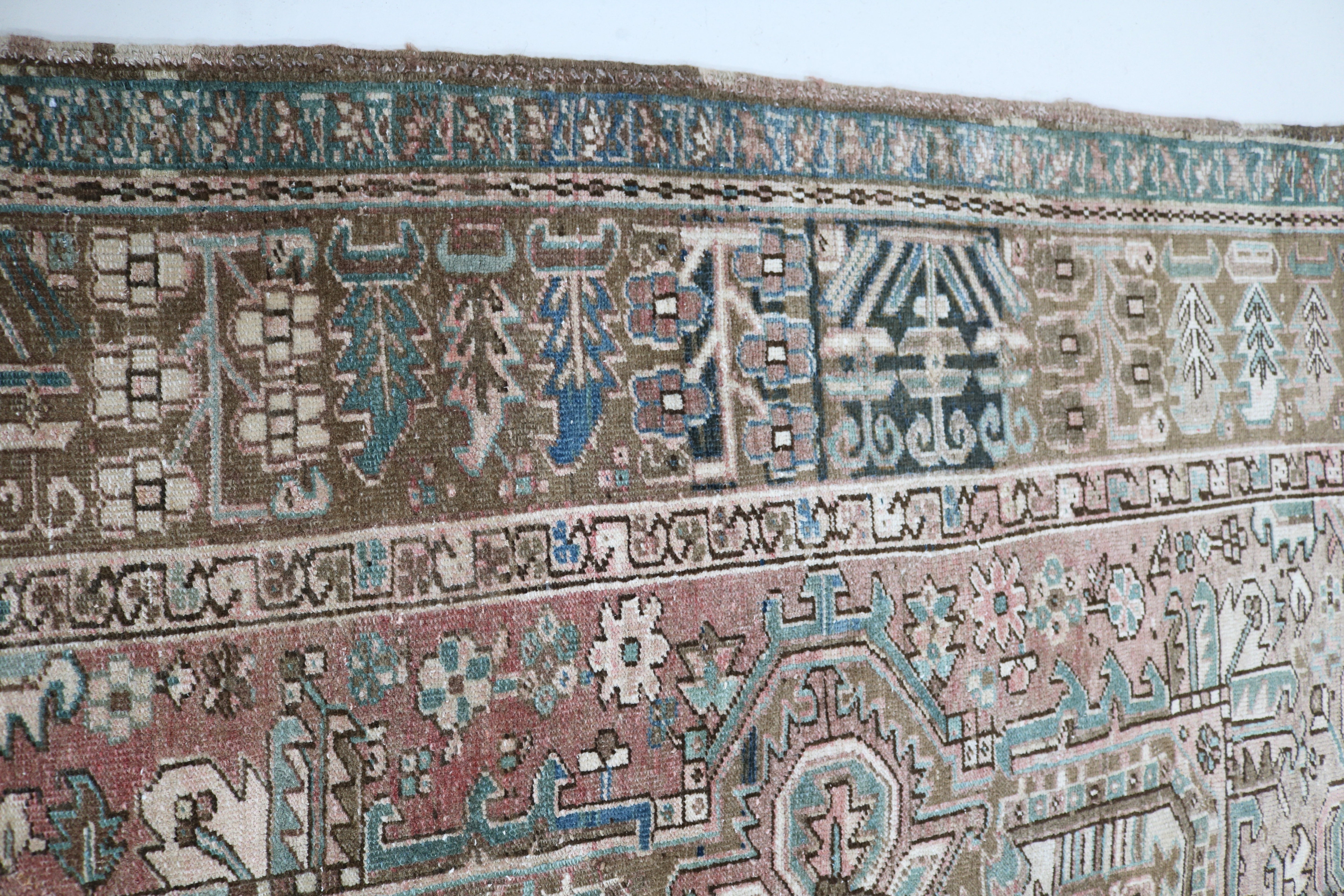 Close-up of hand-knotted wool texture on antique Persian Heriz carpet
