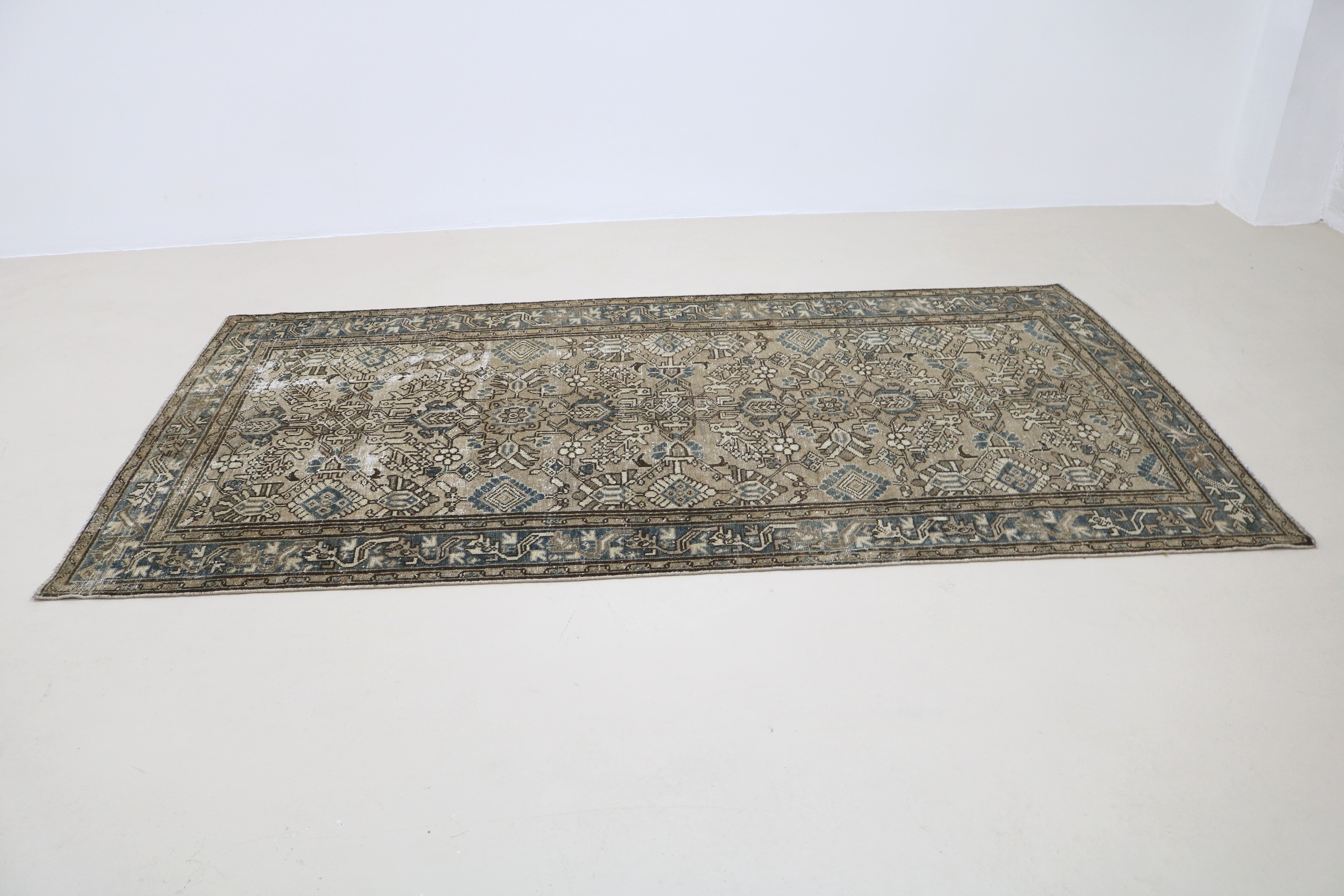 Perspective view of antique Persian Karaja rug laid on floor
