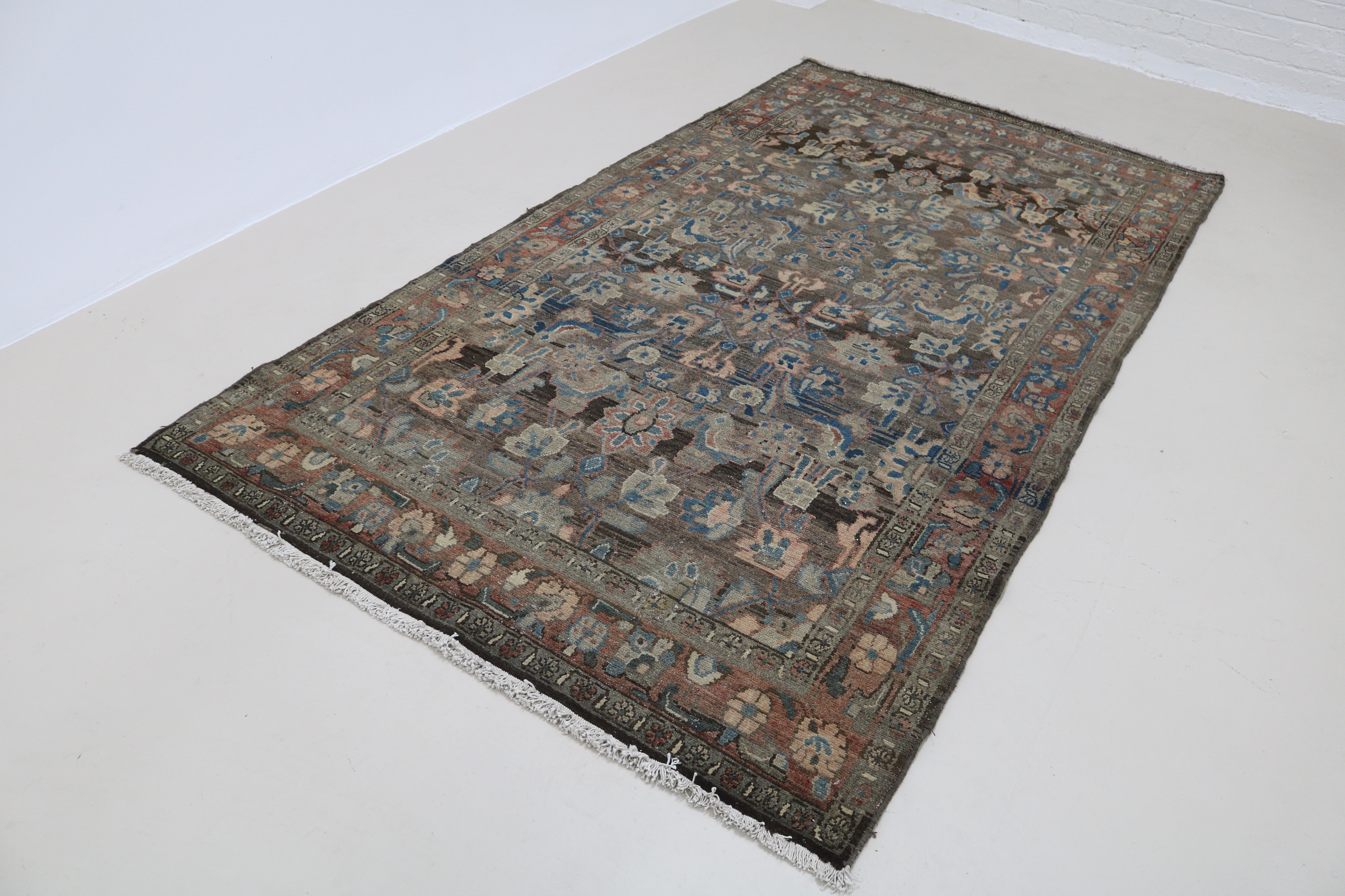 Angled view of antique Persian Malayer rug highlighting overall pattern and composition
