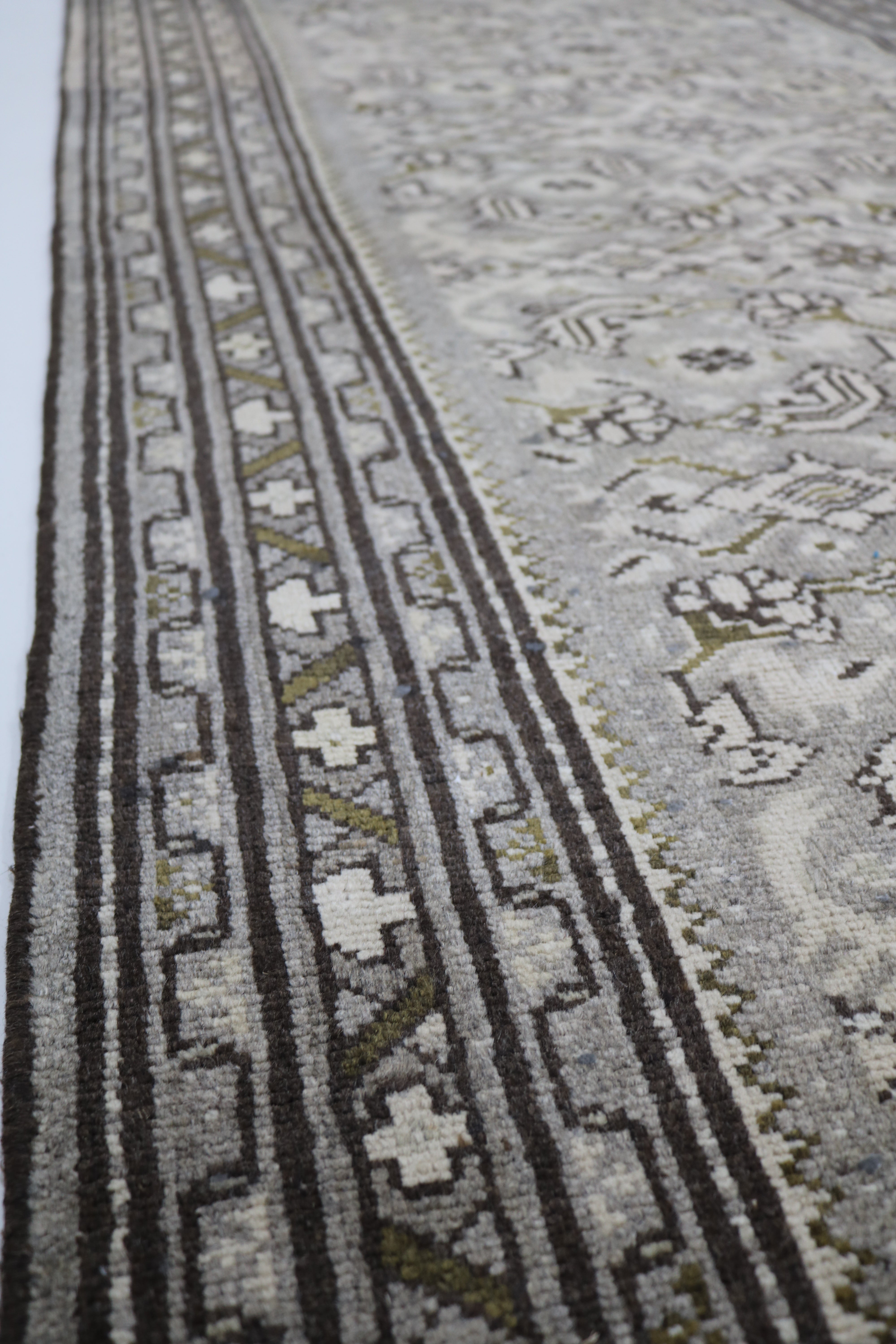 Close-up of traditional border pattern on vintage Persian Malayer runner
