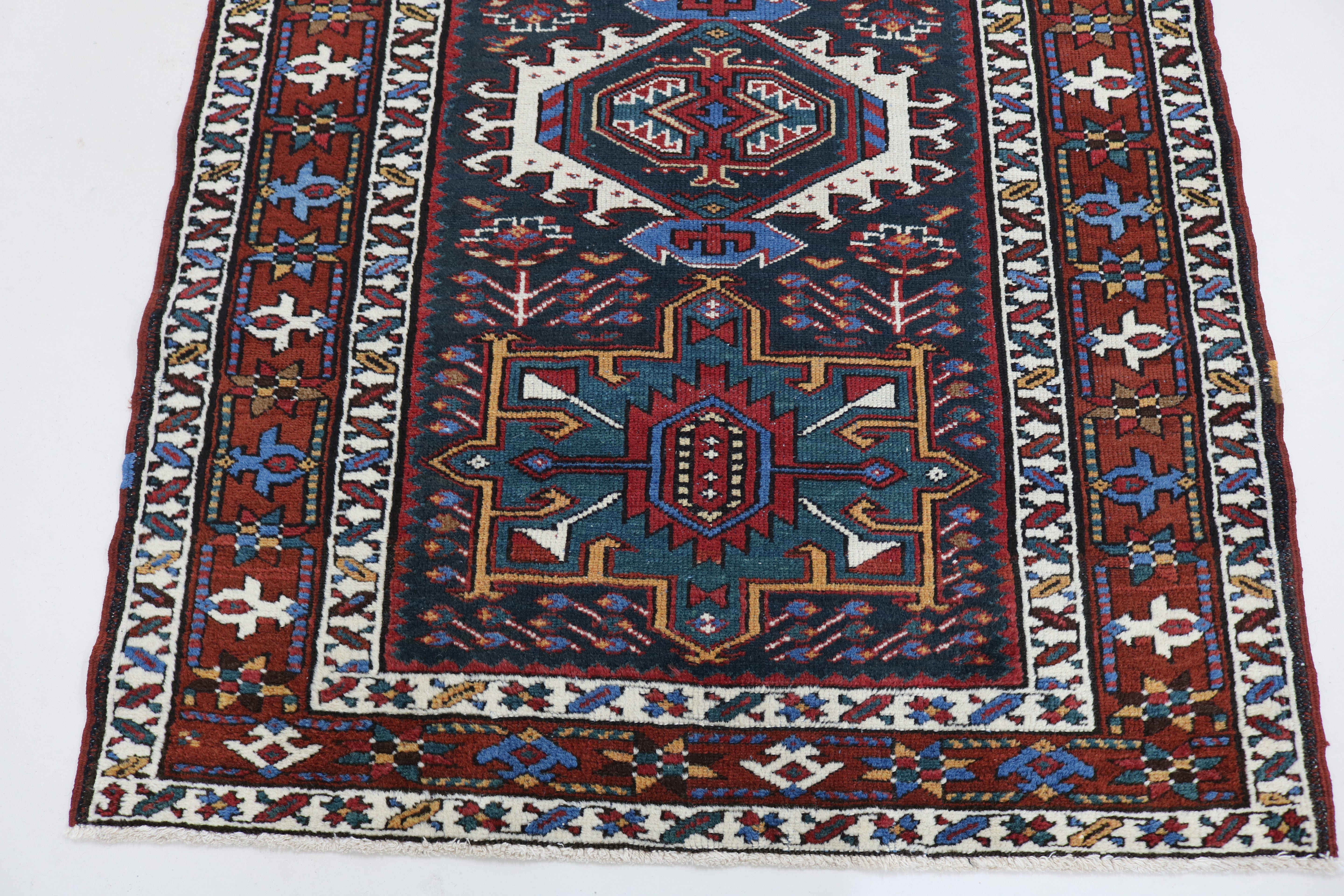 Close-up of hand-knotted wool texture on antique Heriz runner

