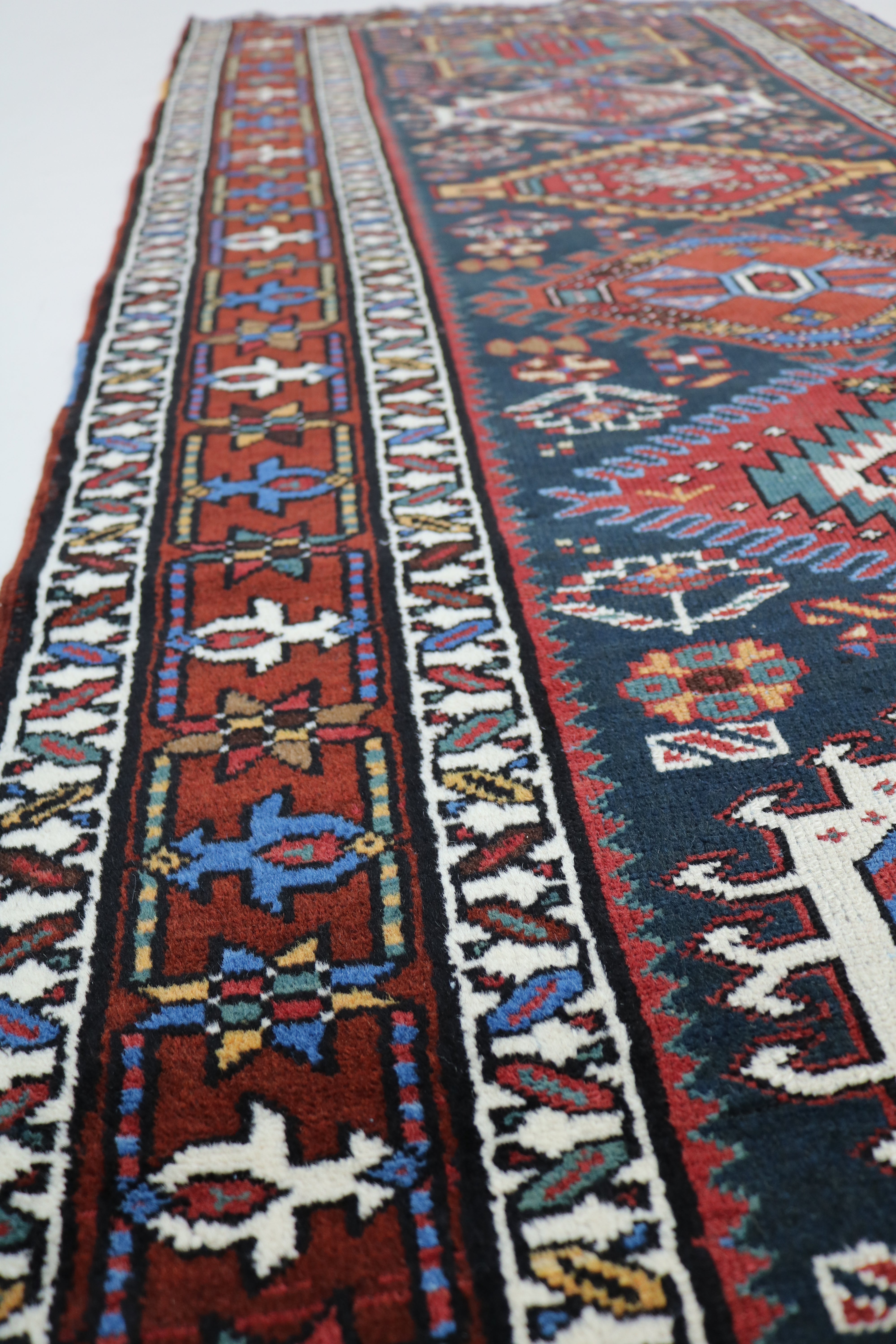 Close-up of hand-knotted wool texture on antique Heriz runner

