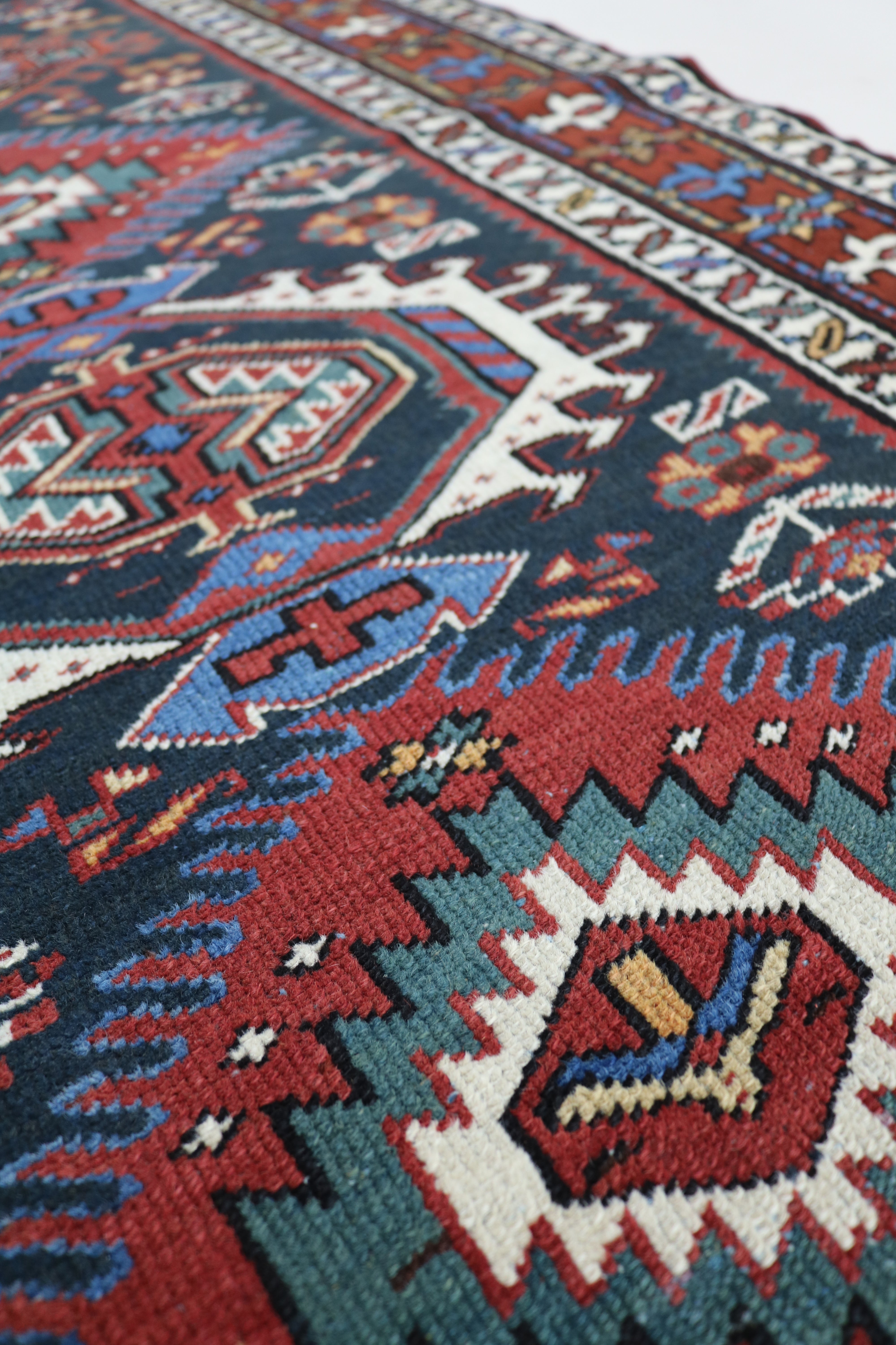 Close-up of hand-knotted wool texture on antique Heriz runner
