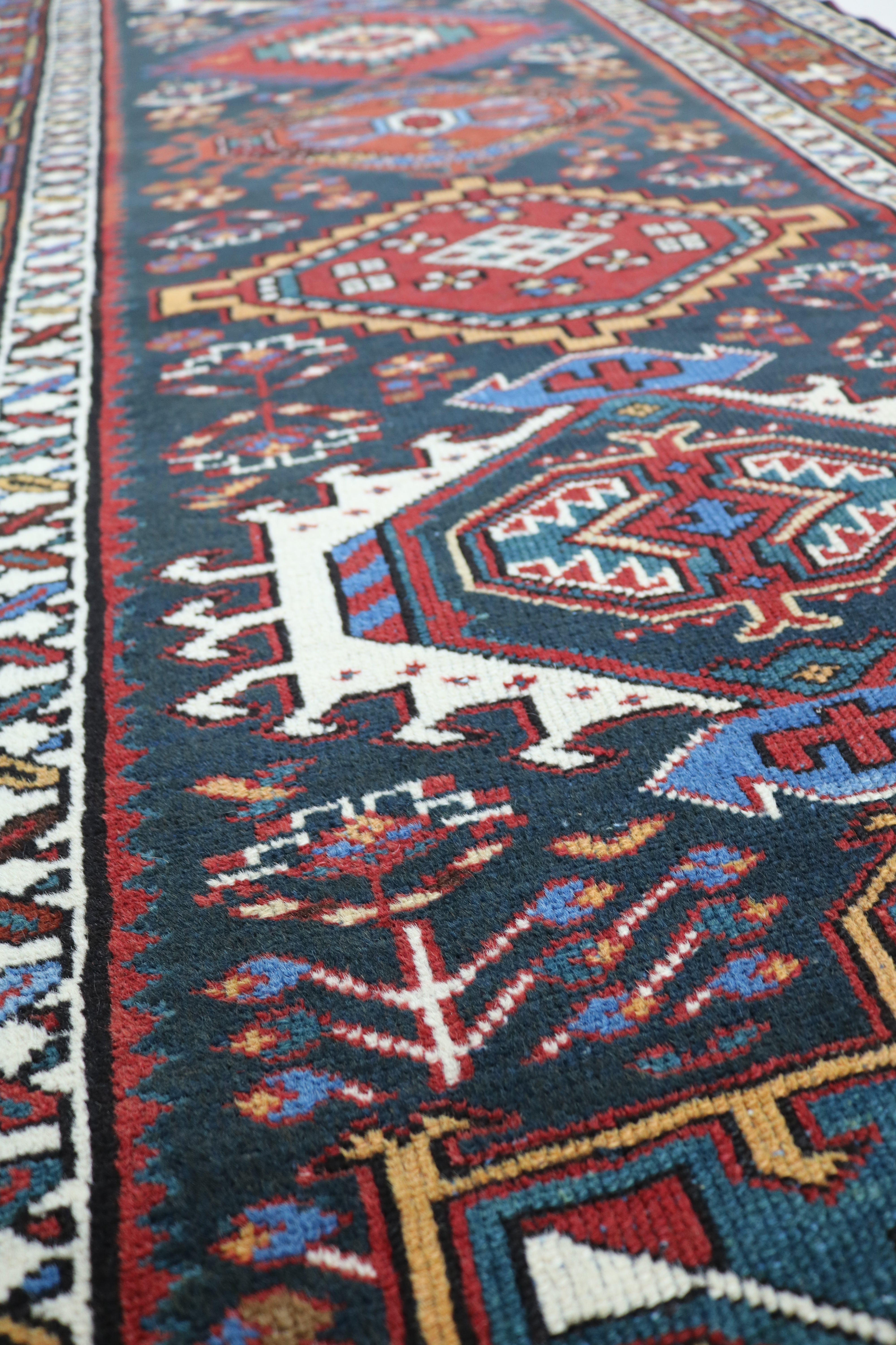 Close-up of hand-knotted wool texture on antique Heriz runner
