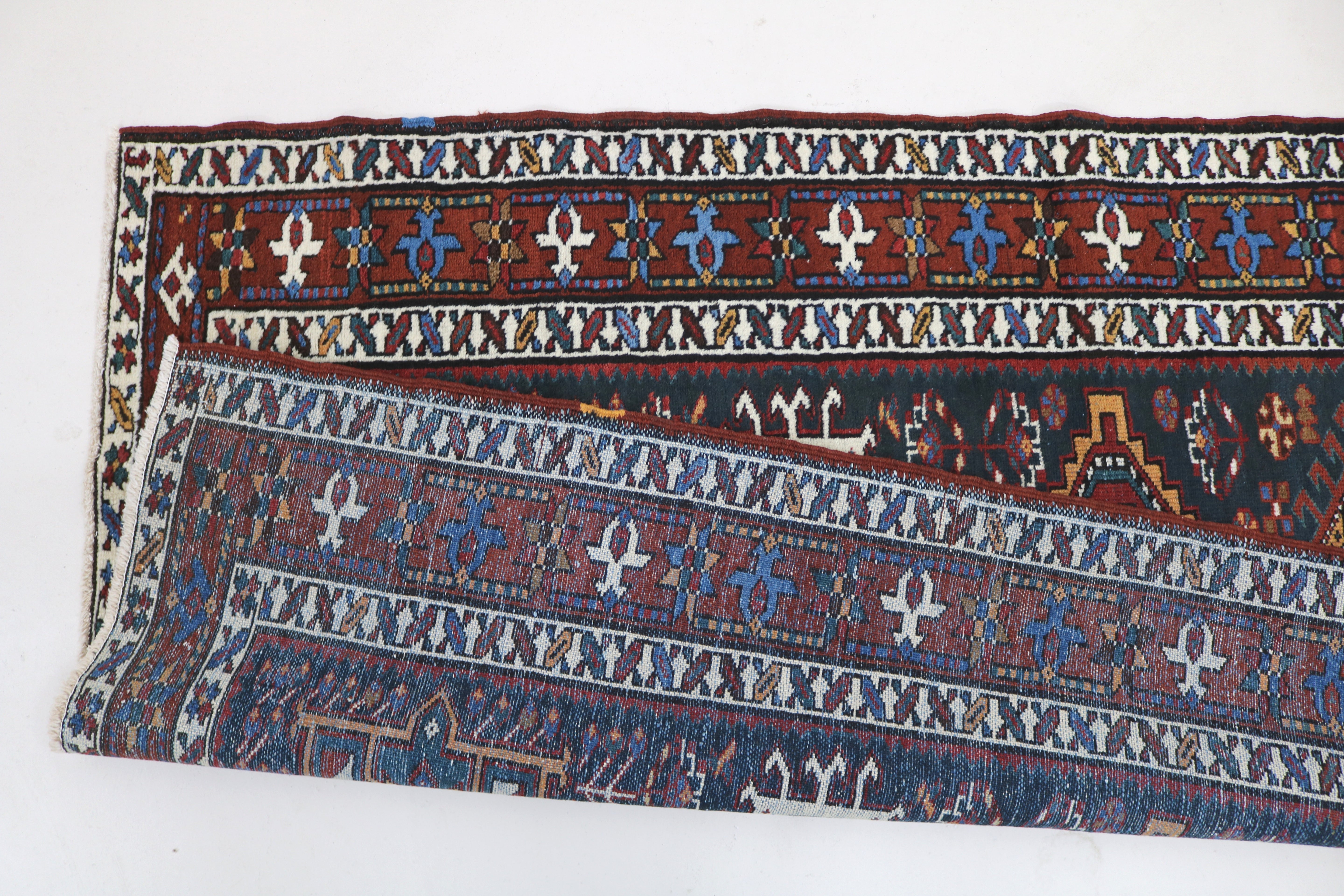 Close-up of hand-knotted wool texture on antique Heriz runner

