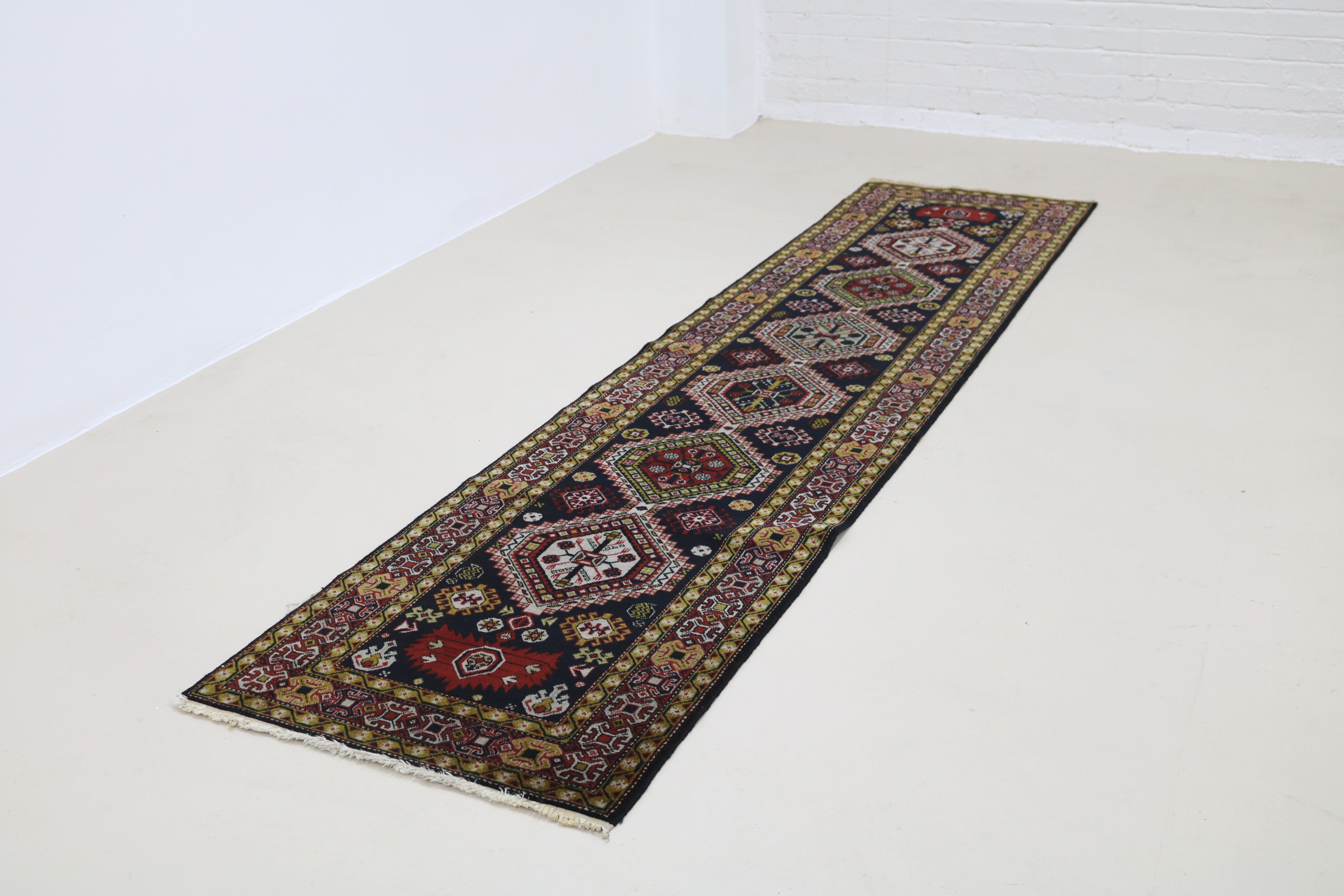Angled view of antique Caucasian Irawan runner highlighting overall pattern and proportions
