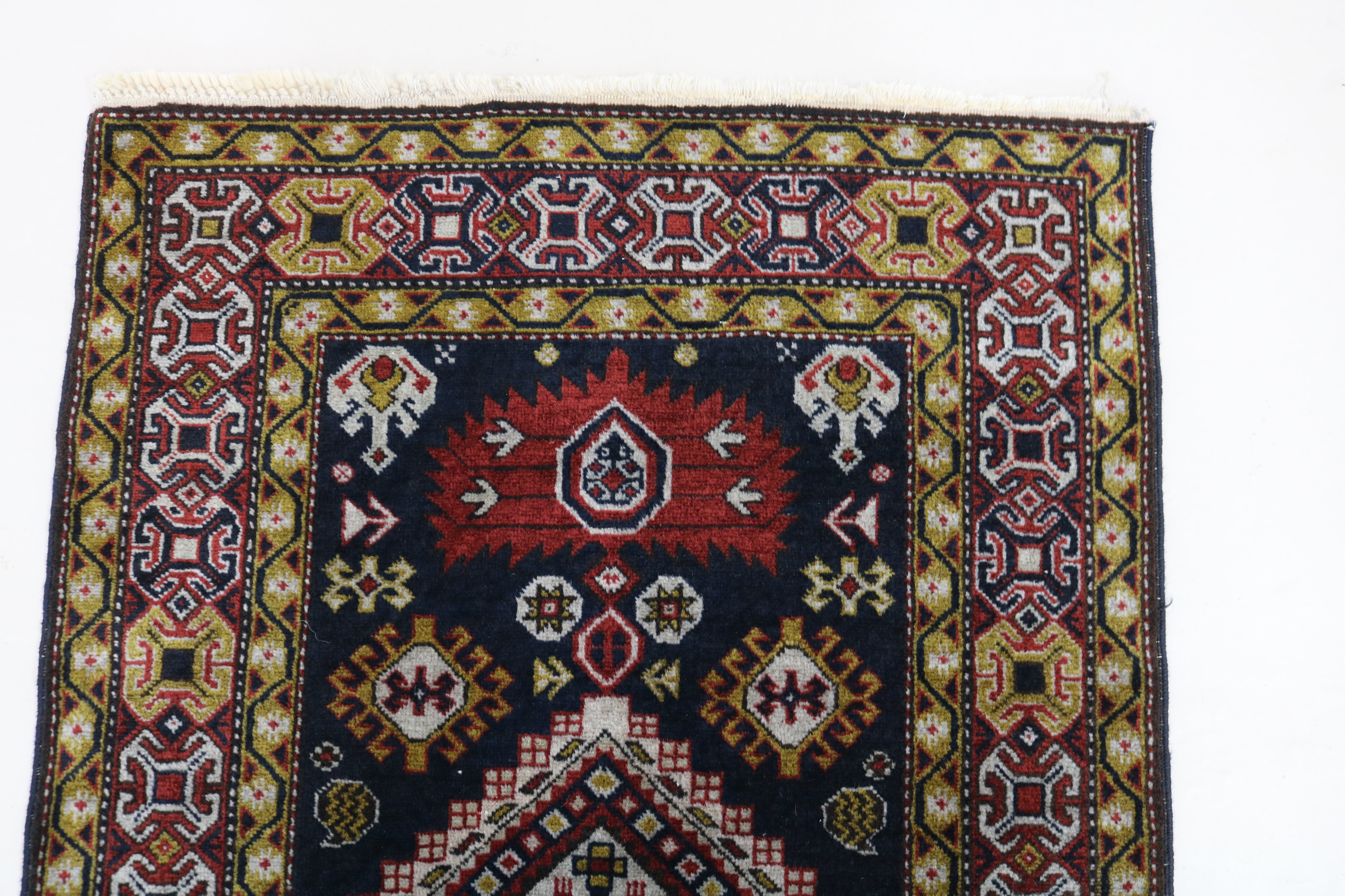 Close-up of hand-knotted wool texture on antique Caucasian Irawan runner
