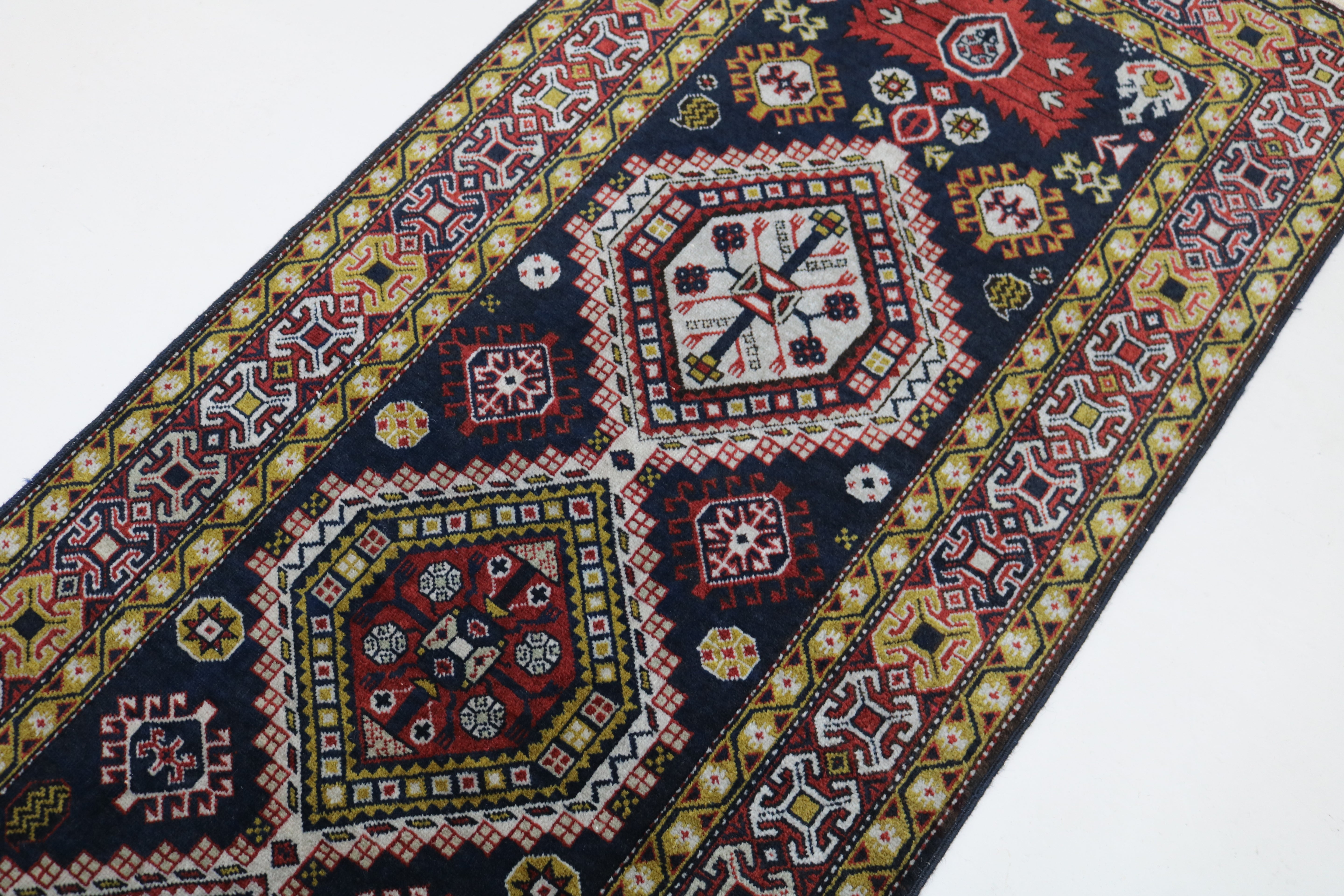Close-up of hand-knotted wool texture on antique Caucasian Irawan runner
