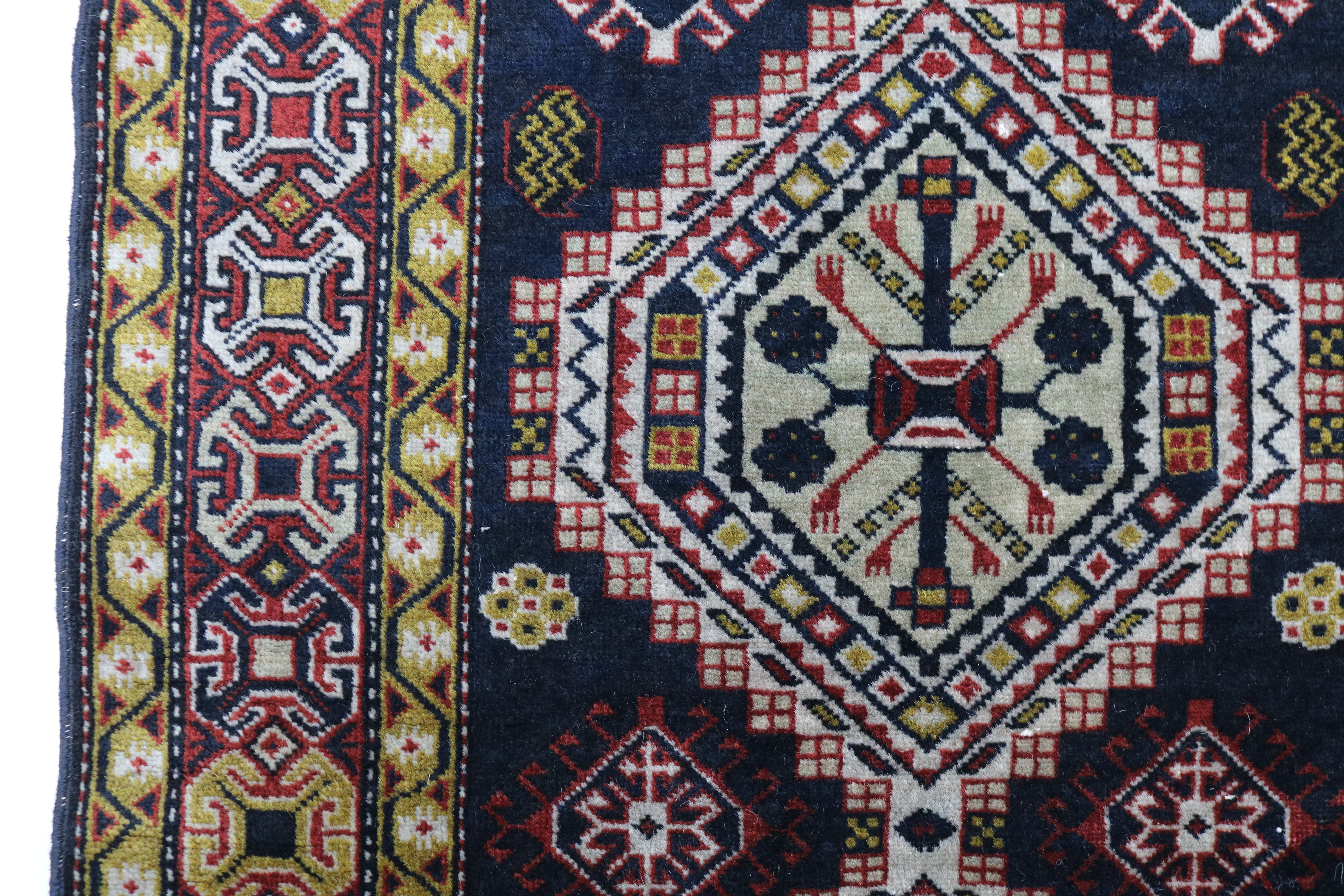 Close-up of hand-knotted wool texture on antique Caucasian Irawan runner

