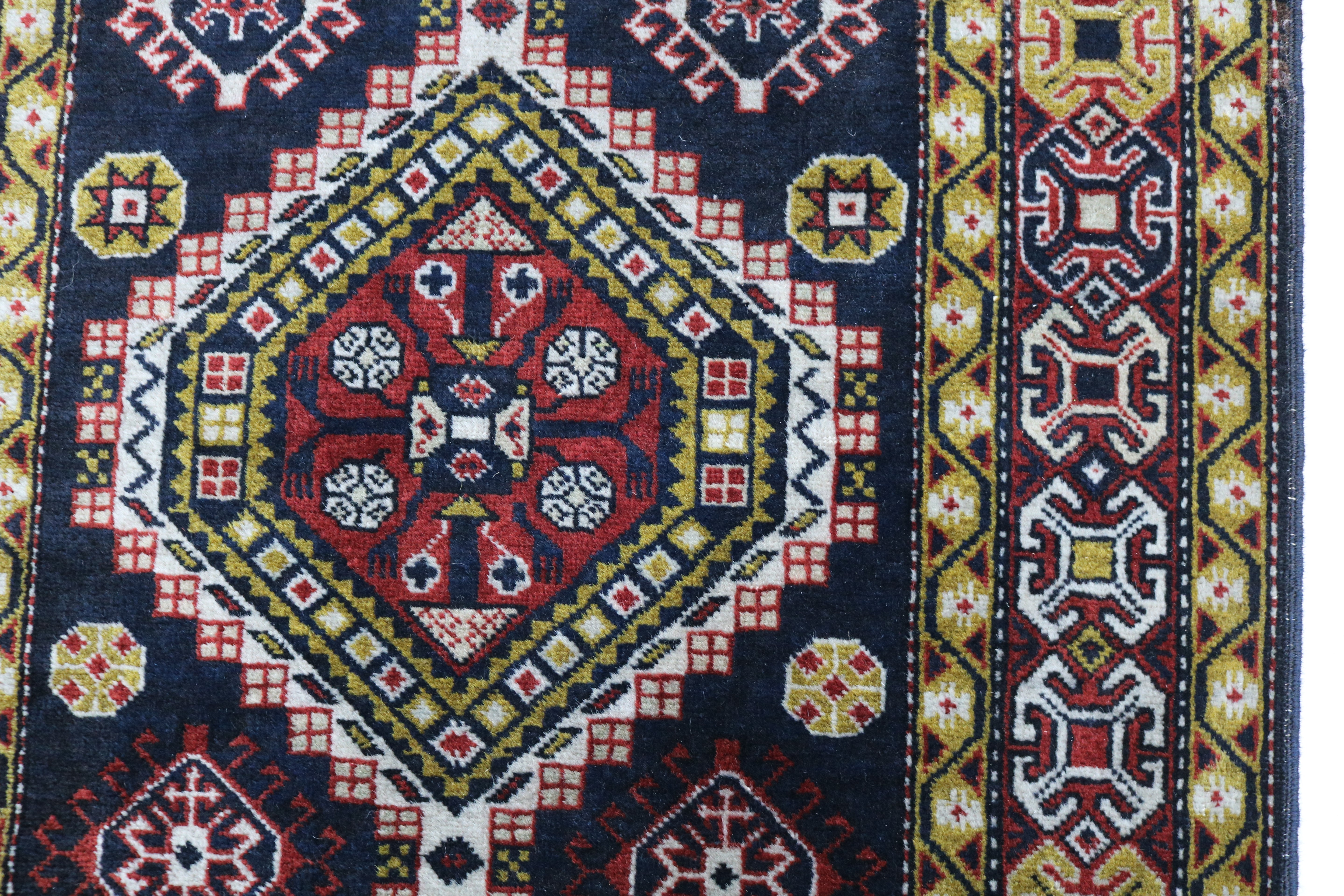 Close-up of hand-knotted wool texture on antique Caucasian Irawan runner
