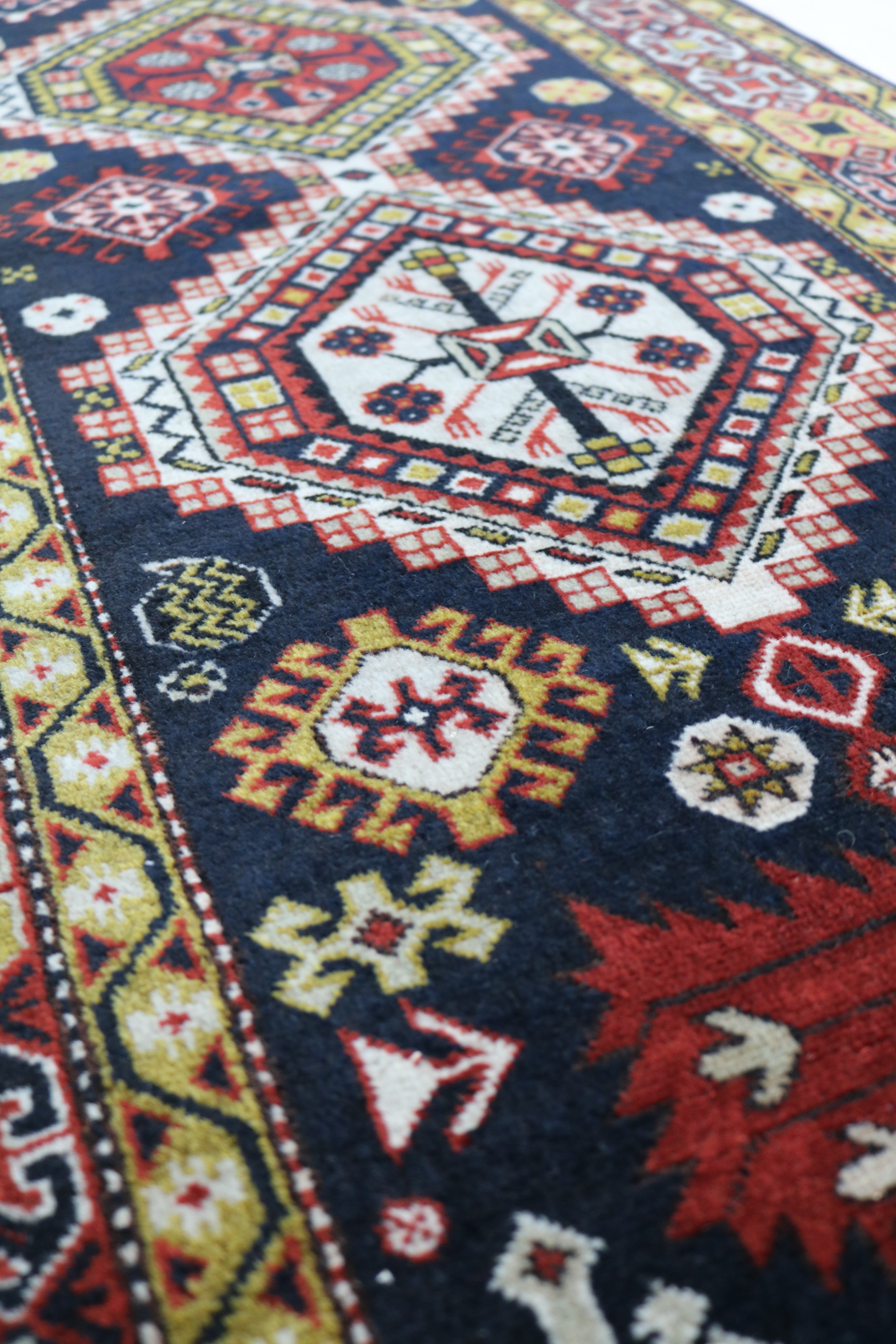 Close-up of hand-knotted wool texture on antique Caucasian Irawan runner
