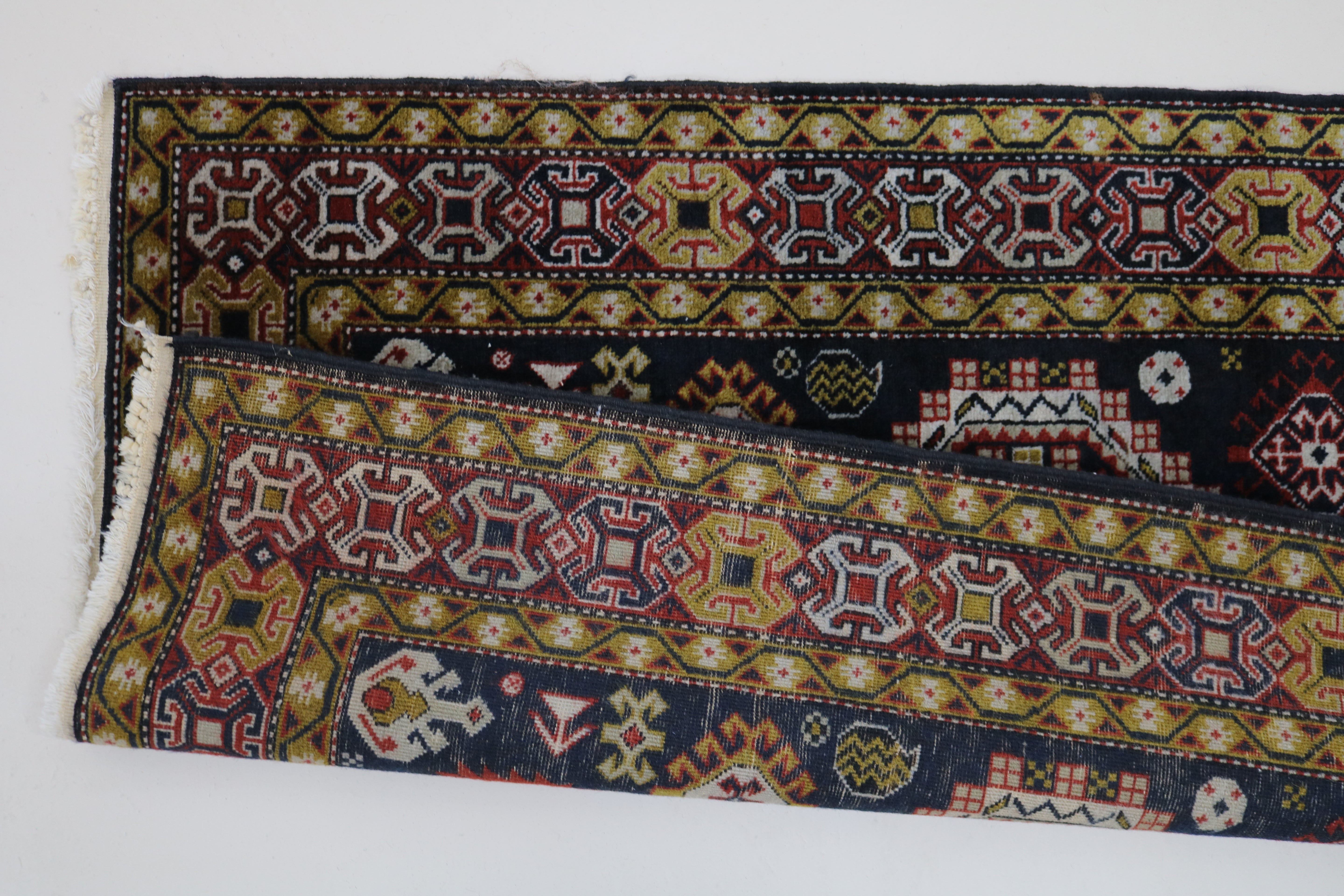 Close-up of hand-knotted wool texture on antique Caucasian Irawan runner
