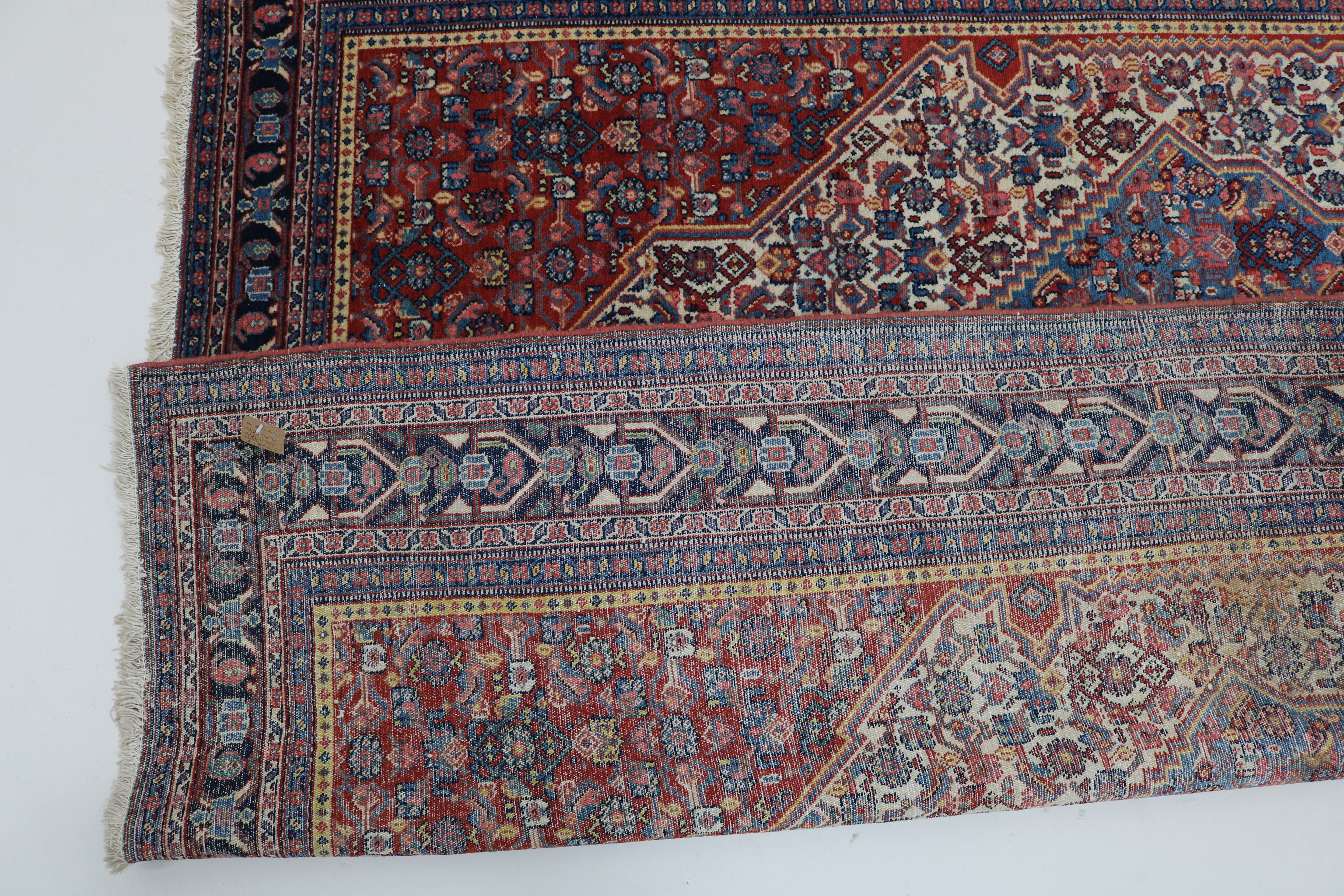 Close-up of finely woven wool texture on antique Persian Senneh rug
