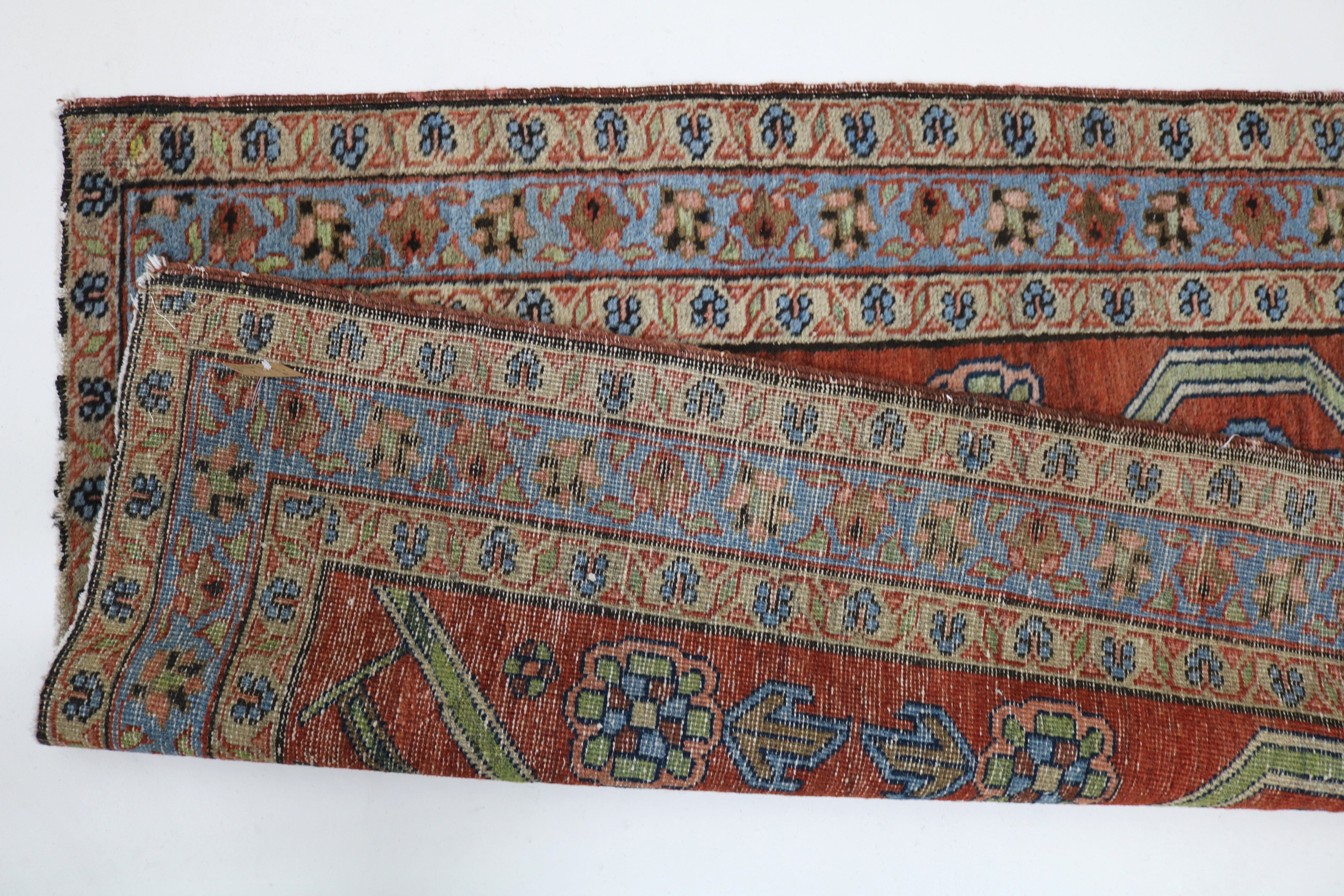 Close-up of hand-knotted wool texture on antique Persian Heriz rug
