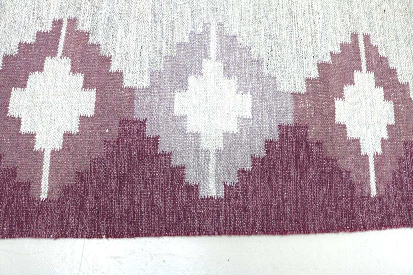 Detail of vintage Swedish Kilim rug showing handwoven wool texture and Scandinavian geometric pattern, mid-century flatweave