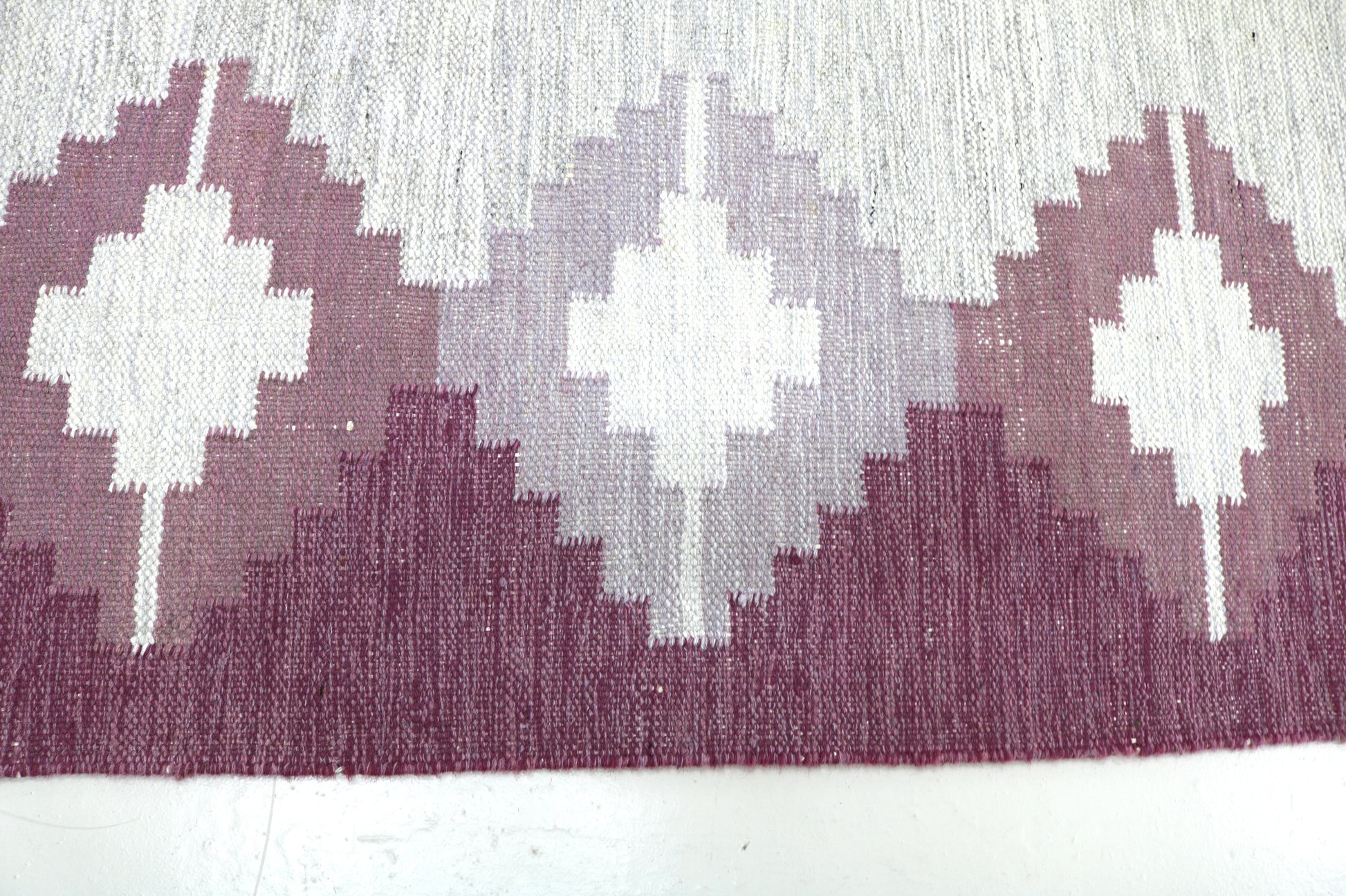 Detail of vintage Swedish Kilim rug showing handwoven wool texture and Scandinavian geometric pattern, mid-century flatweave