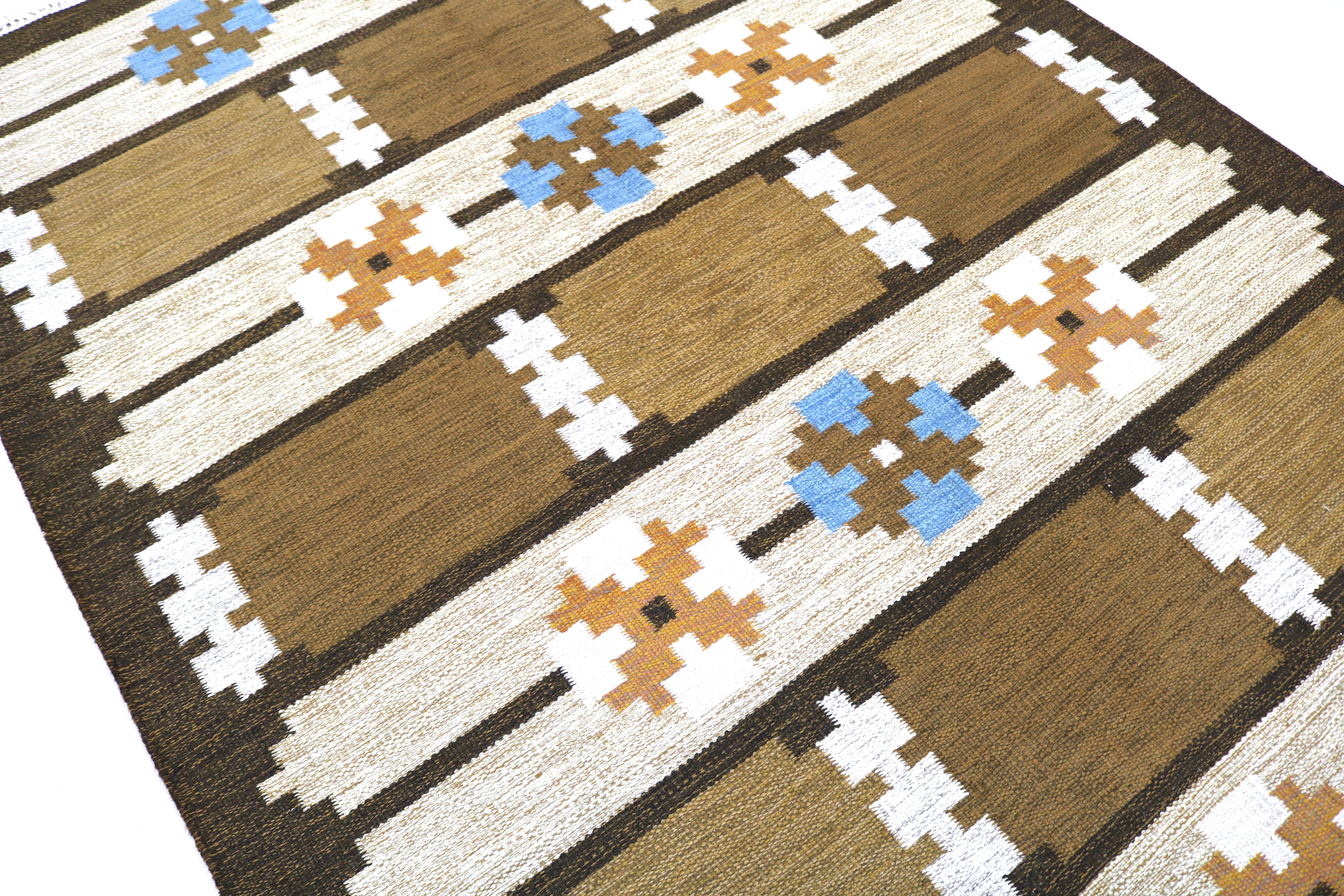Close-up of handwoven Swedish wool kilim with blue floral-inspired motifs.