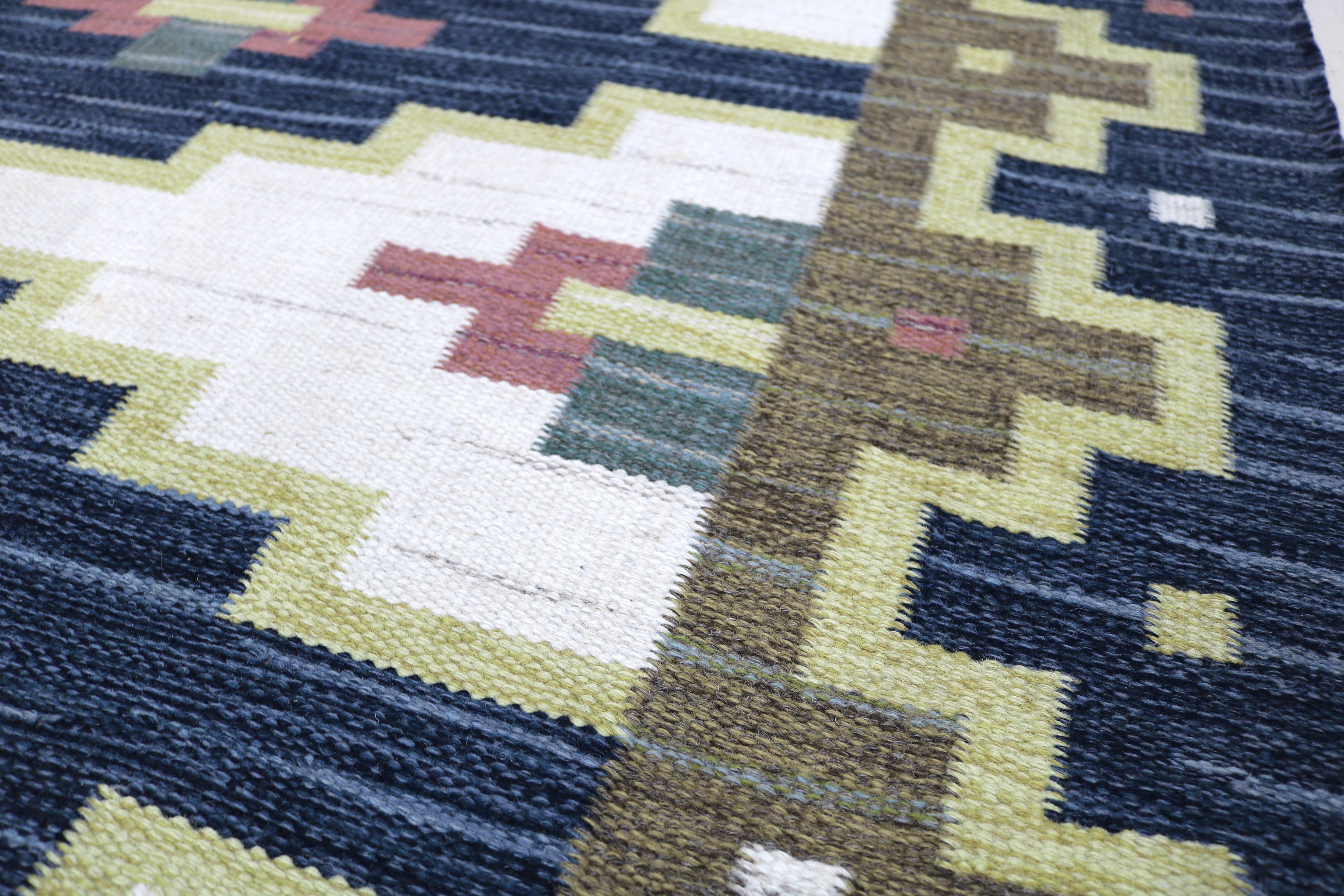 Close-up of the wool texture and craftsmanship of an authentic vintage Swedish kilim.