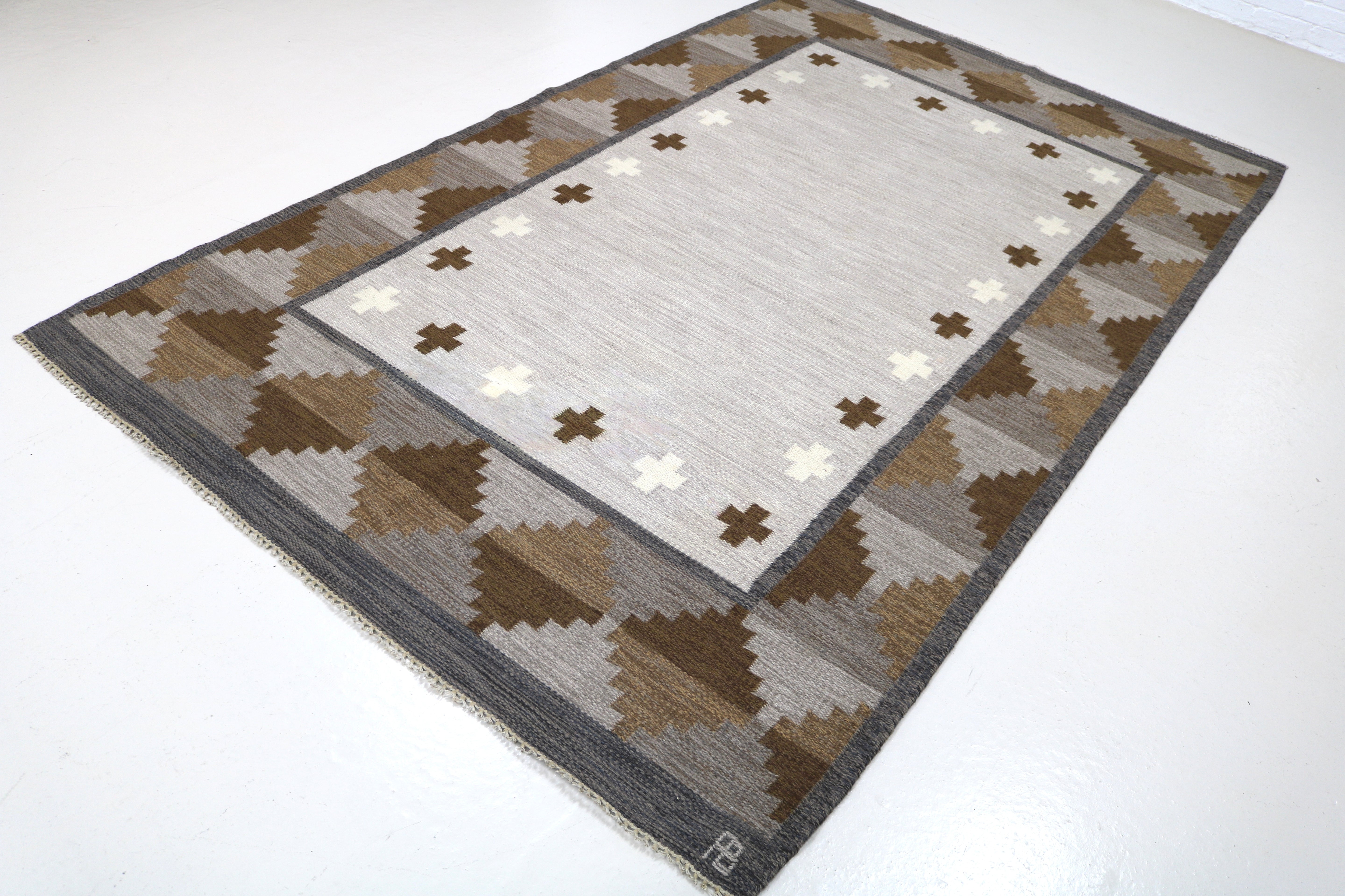 Angled view of vintage Swedish rug showing elegant geometric border.