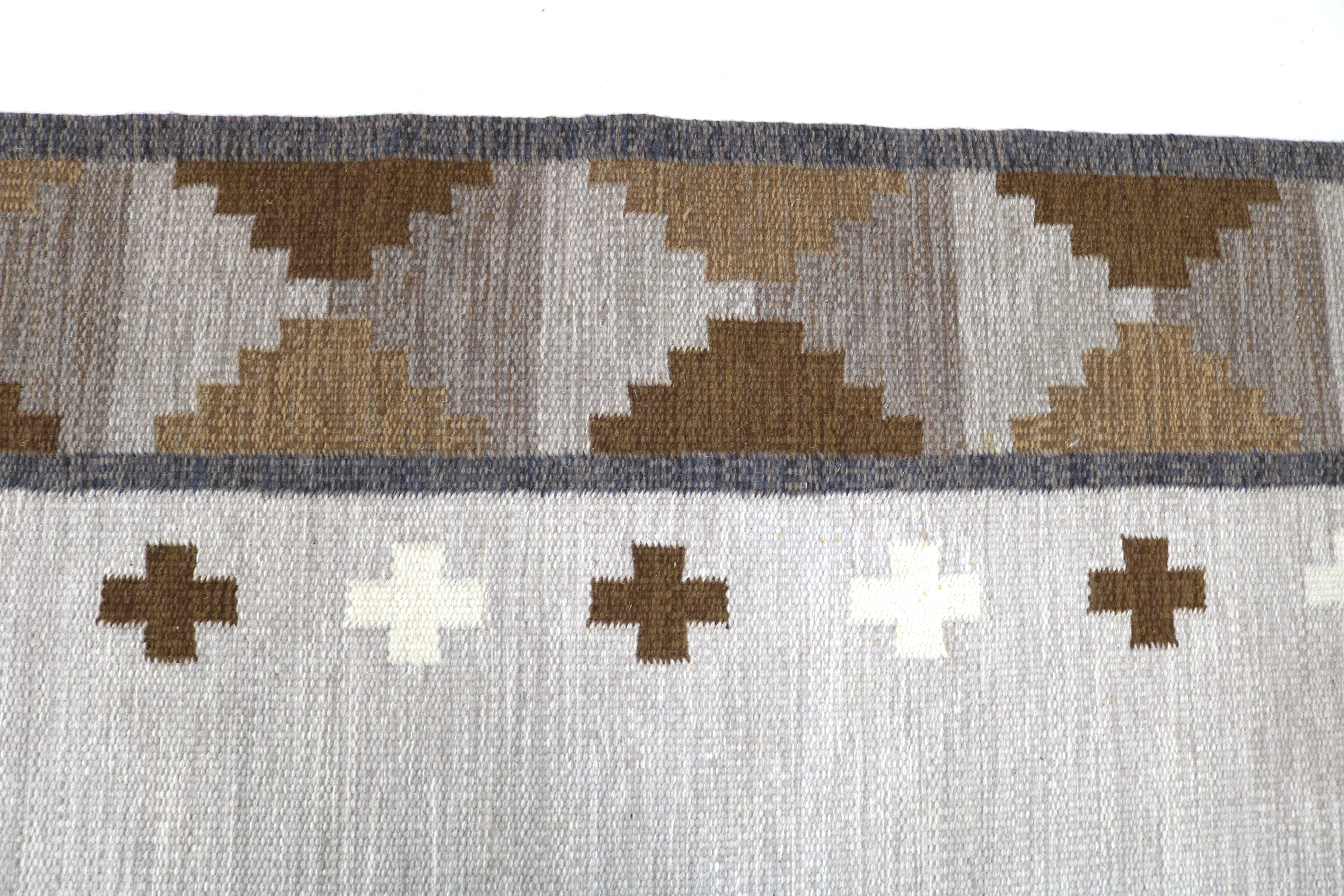 Detail of handwoven Scandinavian kilim featuring warm neutral tones.