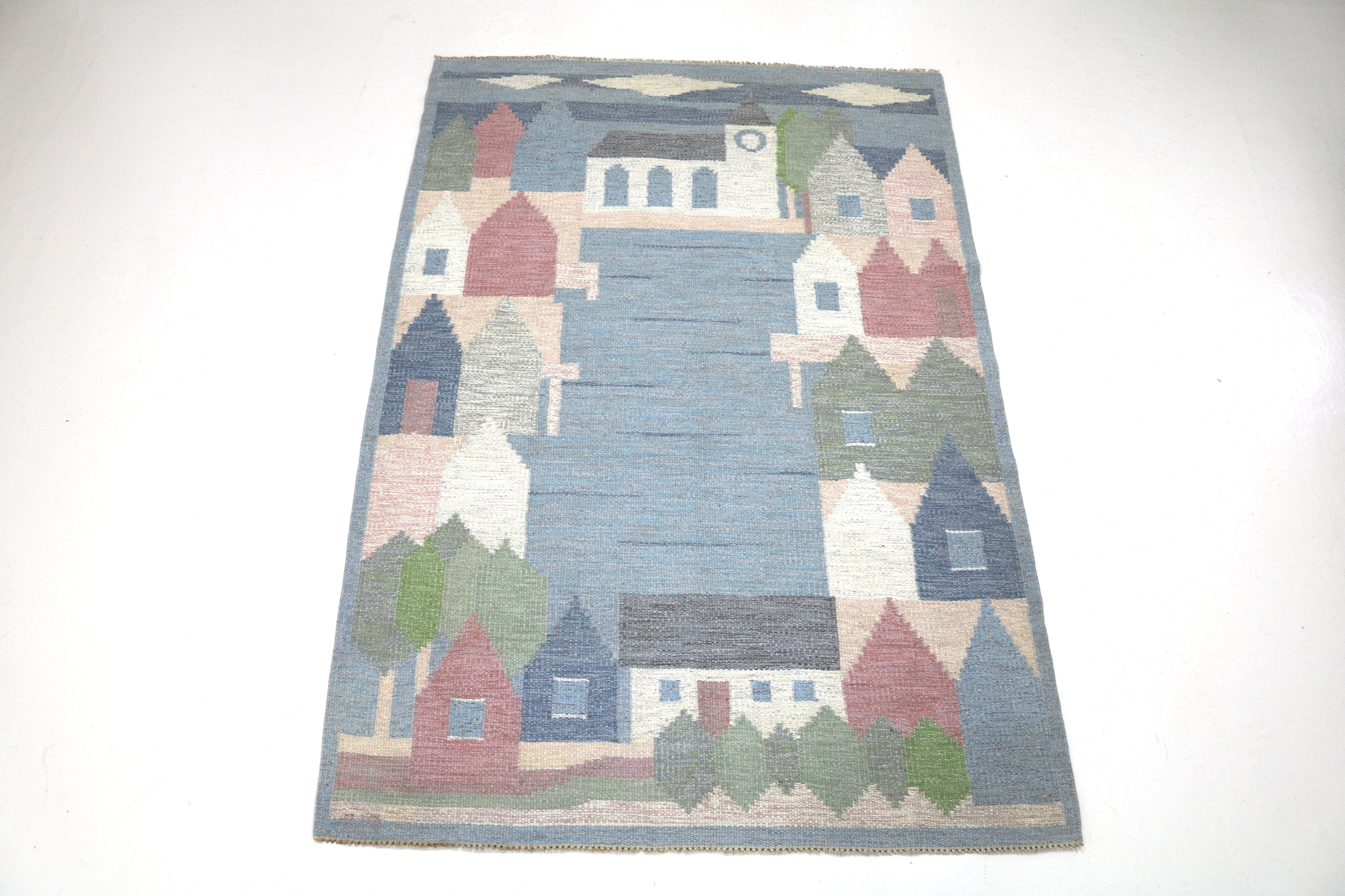 Full view of a handwoven vintage Swedish wool rug with pictorial village design.