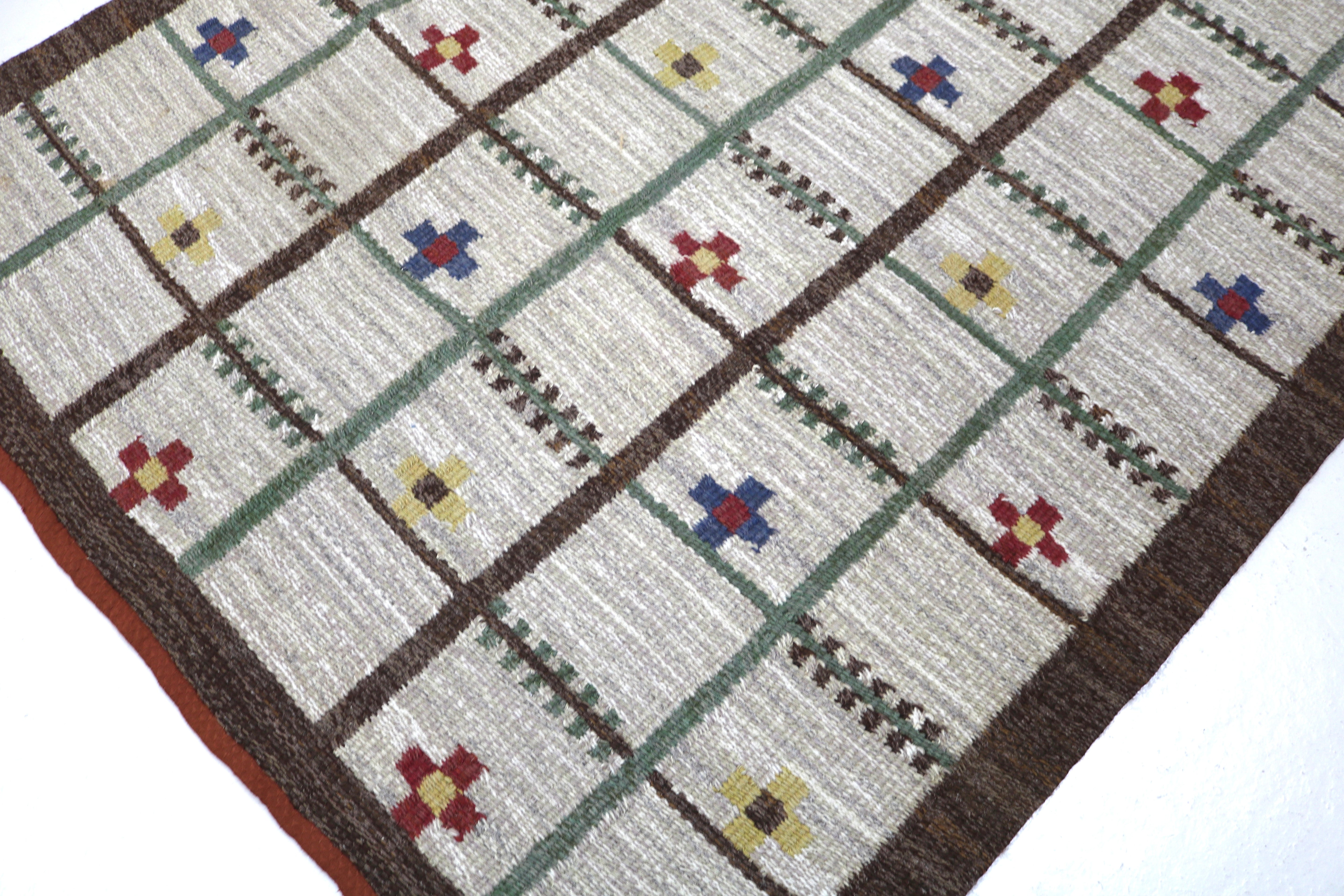 Corner detail of a mid-century Swedish flatweave rug with geometric motifs.