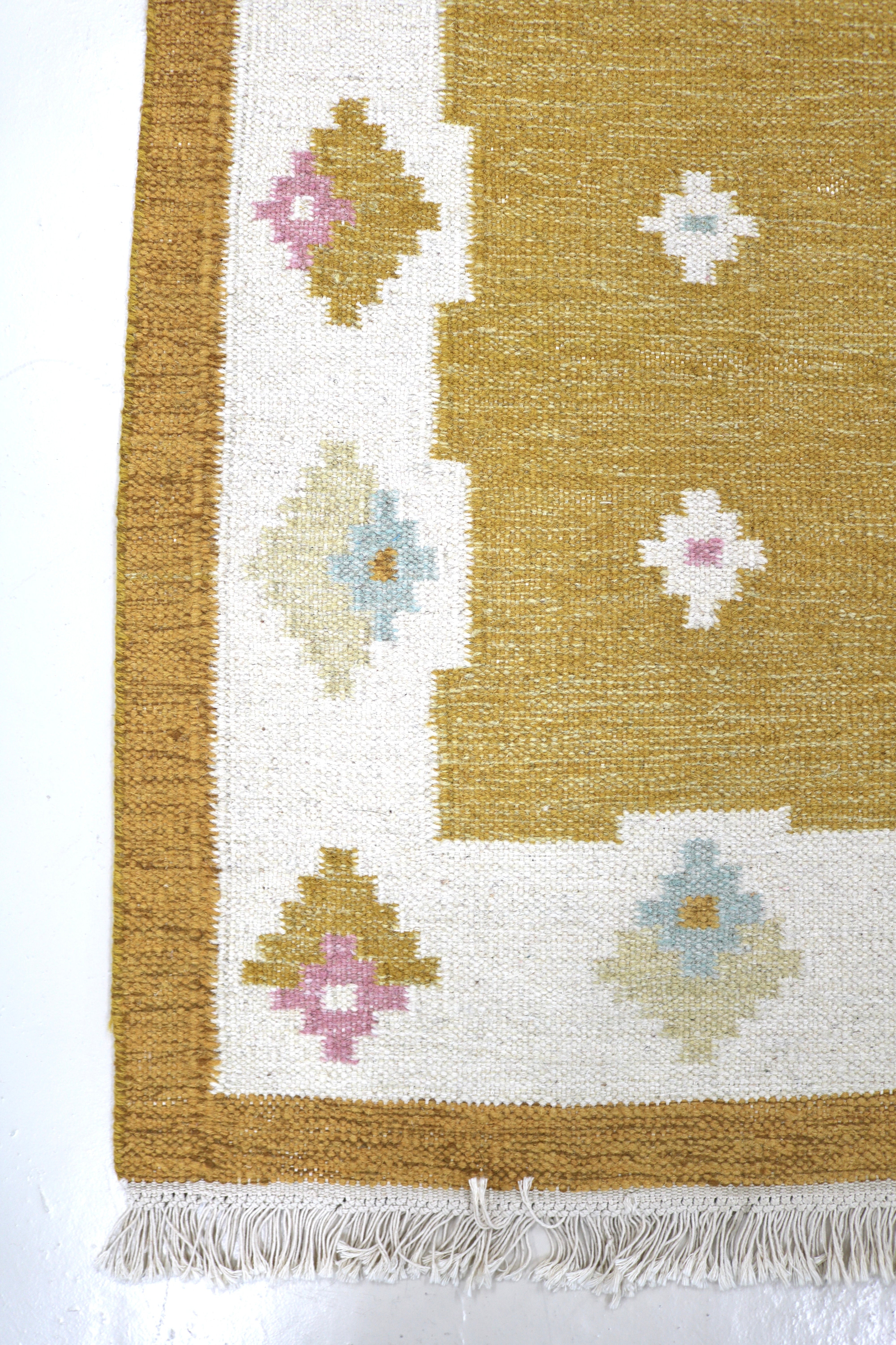 Vintage Swedish kilim runner 350 × 81 cm with floral motifs on a golden ochre background.