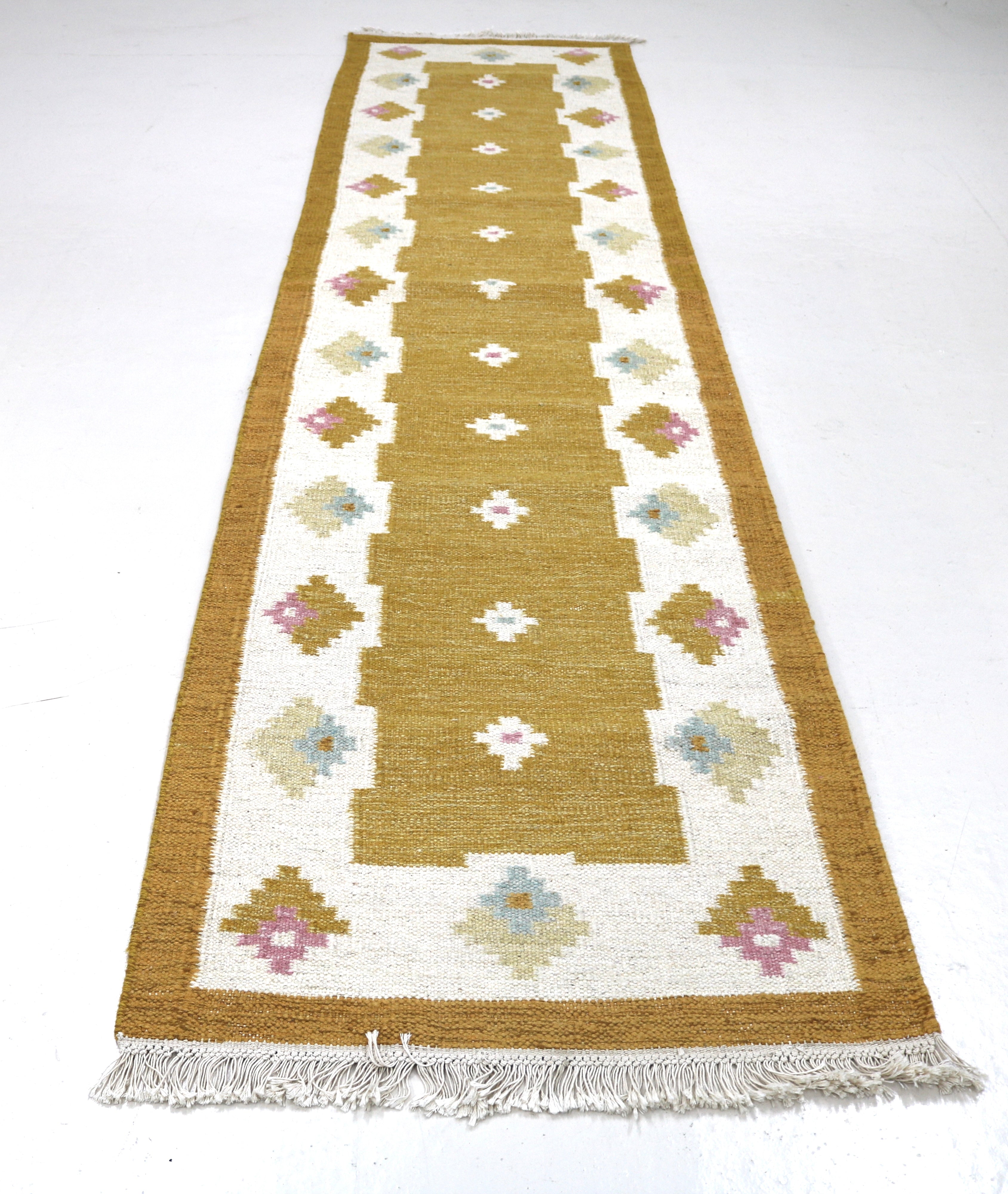 Handwoven Scandinavian kilim runner featuring stylised floral motifs.