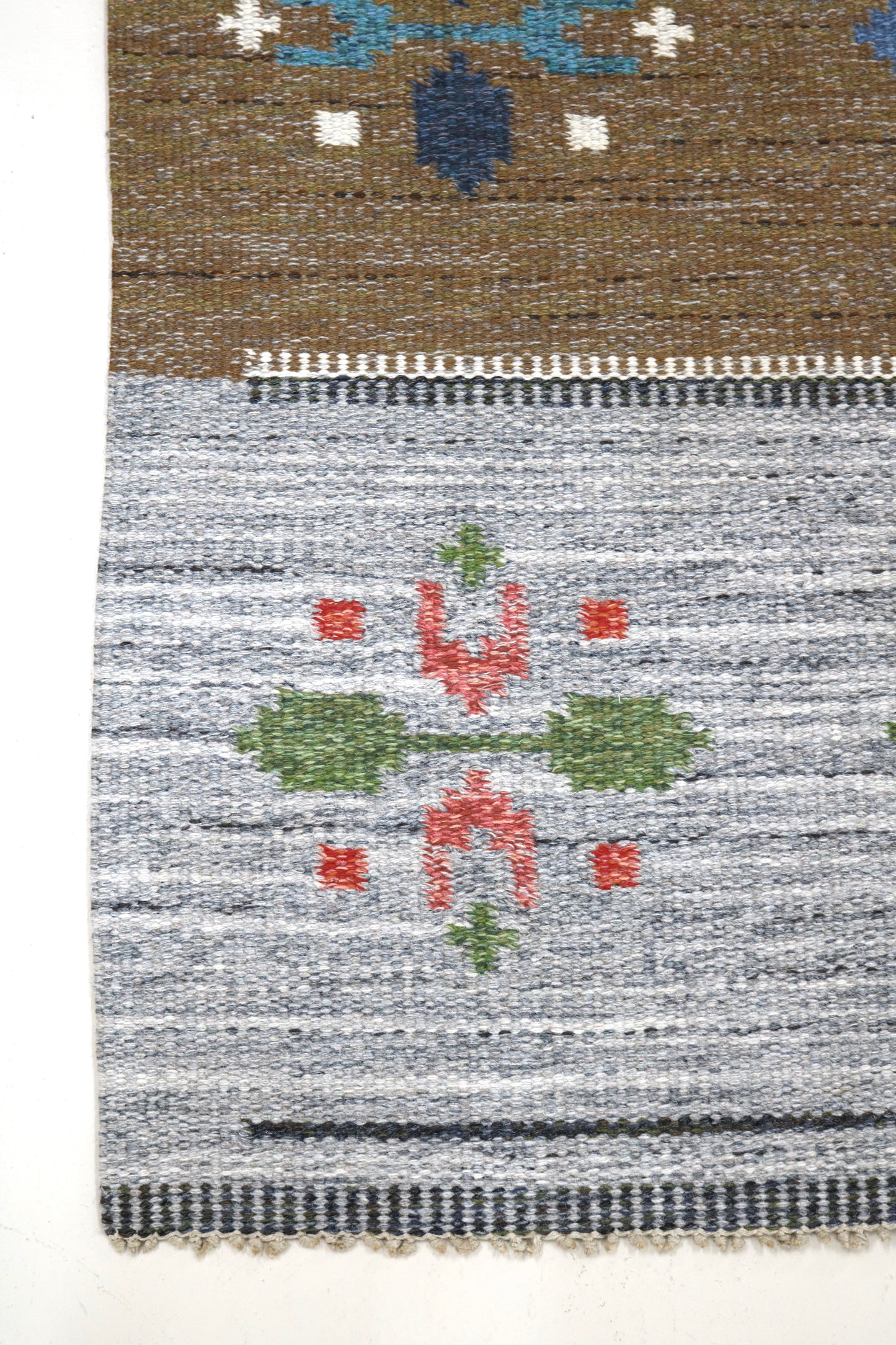 Vintage Swedish kilim runner shown in angled studio view, handwoven wool rug with soft muted colours
