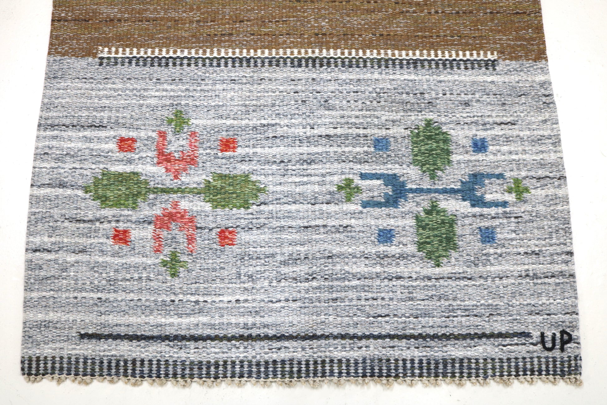 Detail of vintage Swedish kilim rug showing handwoven texture, geometric motifs, and natural wool colours
